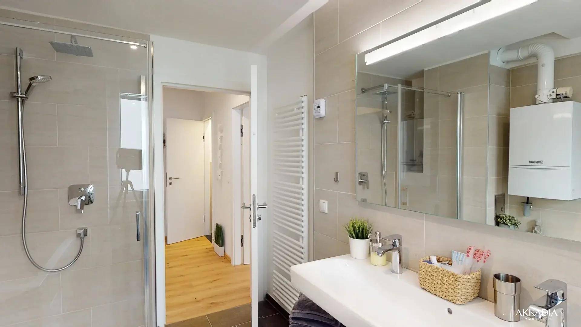 Modernes Badezimmer mit ebenerdiger Dusche, Einzelwaschbecken und Handtuchheizkörper.