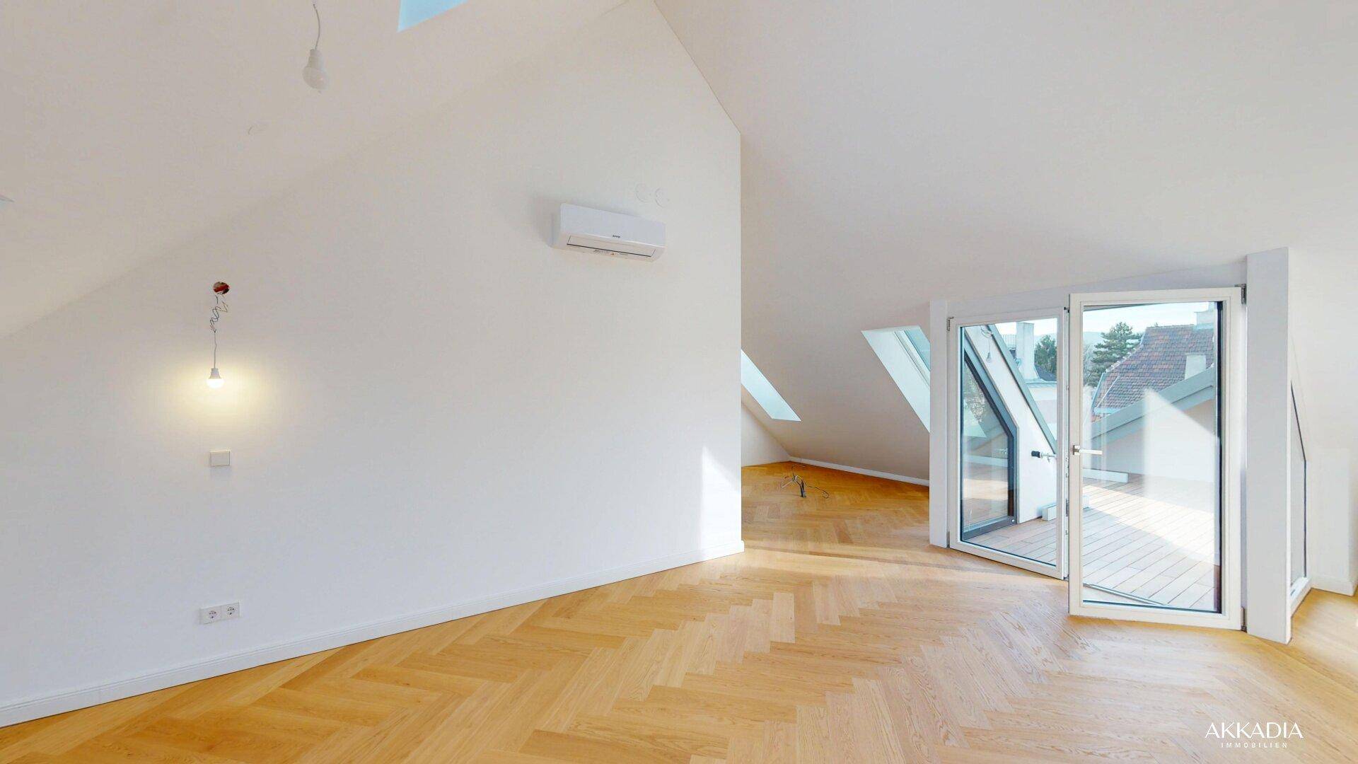 Lichtdurchfluteter Dachgeschossraum mit Klimaanlage, Fischgrätparkett und Terrassenzugang.