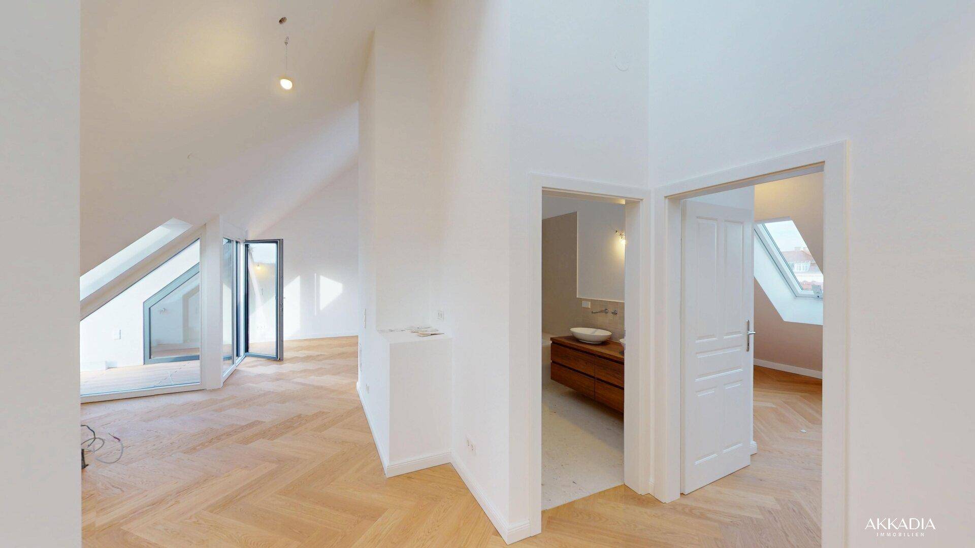 Blick vom Flur in ein modernes Badezimmer mit Doppelwaschbecken und Badewanne.