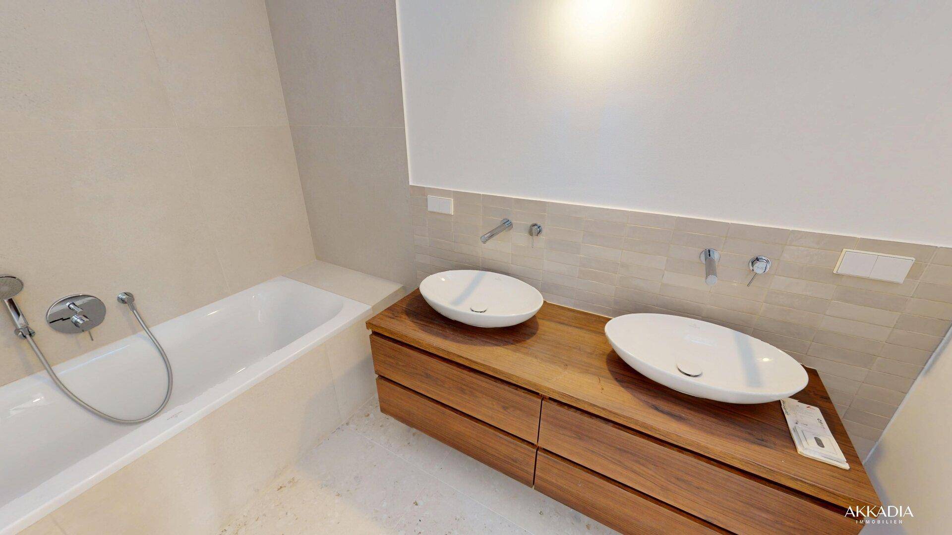 Elegantes Badezimmer mit zwei Aufsatzwaschbecken auf Holzunterschrank und Badewanne.