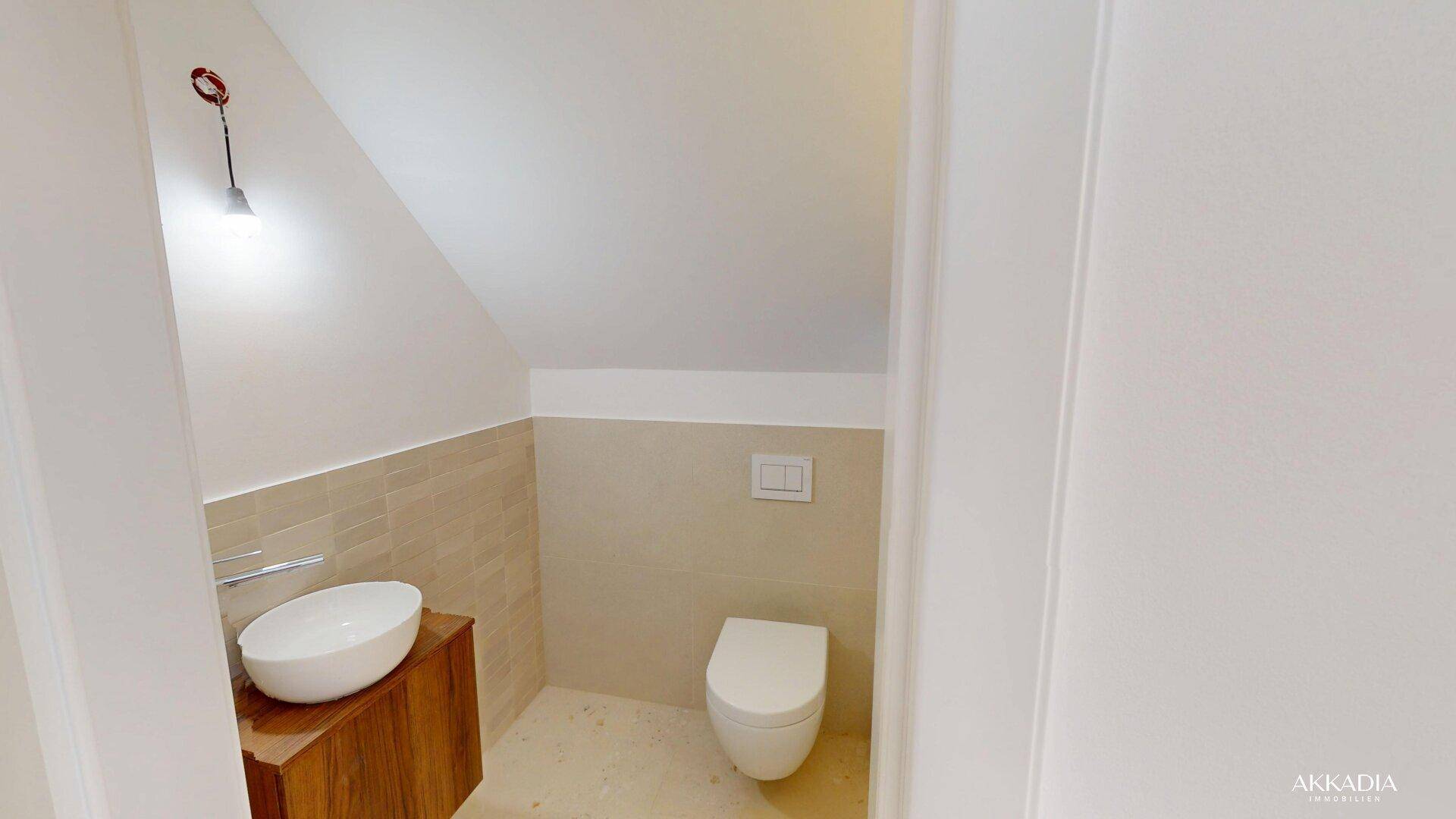 Modernes Gäste-WC mit wandhängendem WC, Aufsatzwaschbecken und Holzunterschrank.
