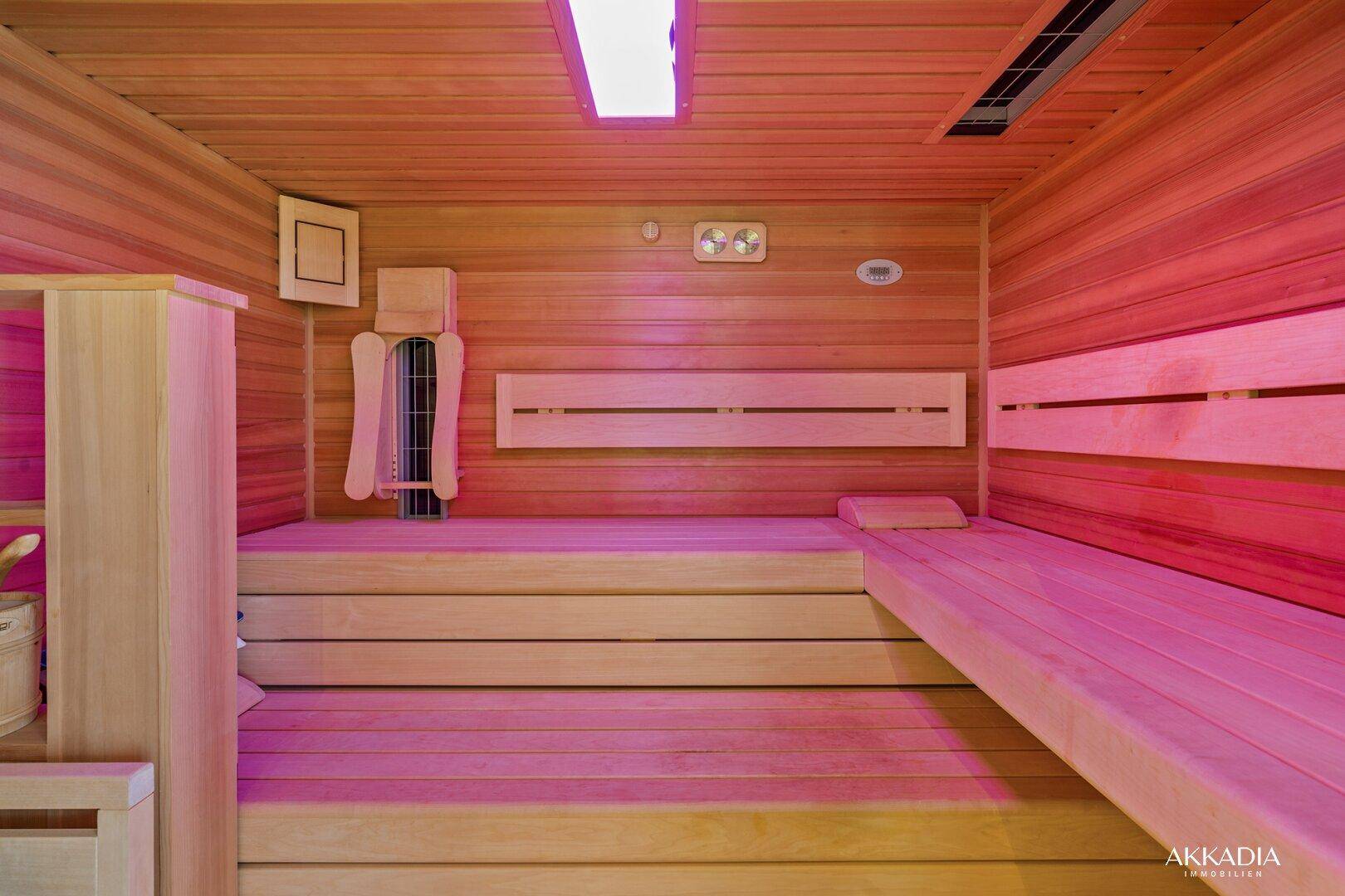 Geräumige Holzsauna mit mehreren Bänken und stimmungsvoller Beleuchtung für Entspannung und Wellness.