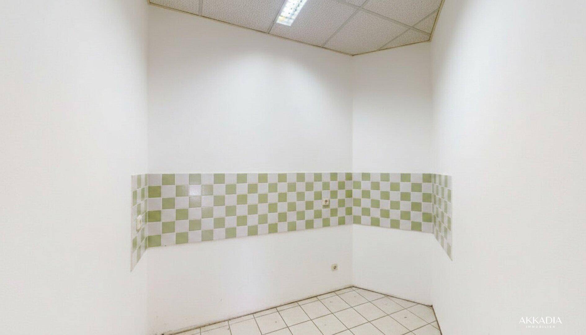 Kleiner Küchenbereich mit karierten Fliesen an der Wand und Bodenfliesen, bereit für die Installation einer Küchenzeile.