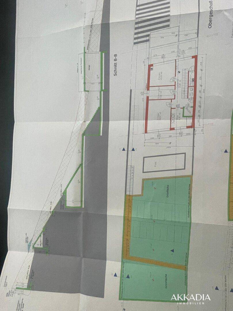 Schnittzeichnung des Gebäudes mit Treppenhaus und angrenzendem Außenbereich und Garten.