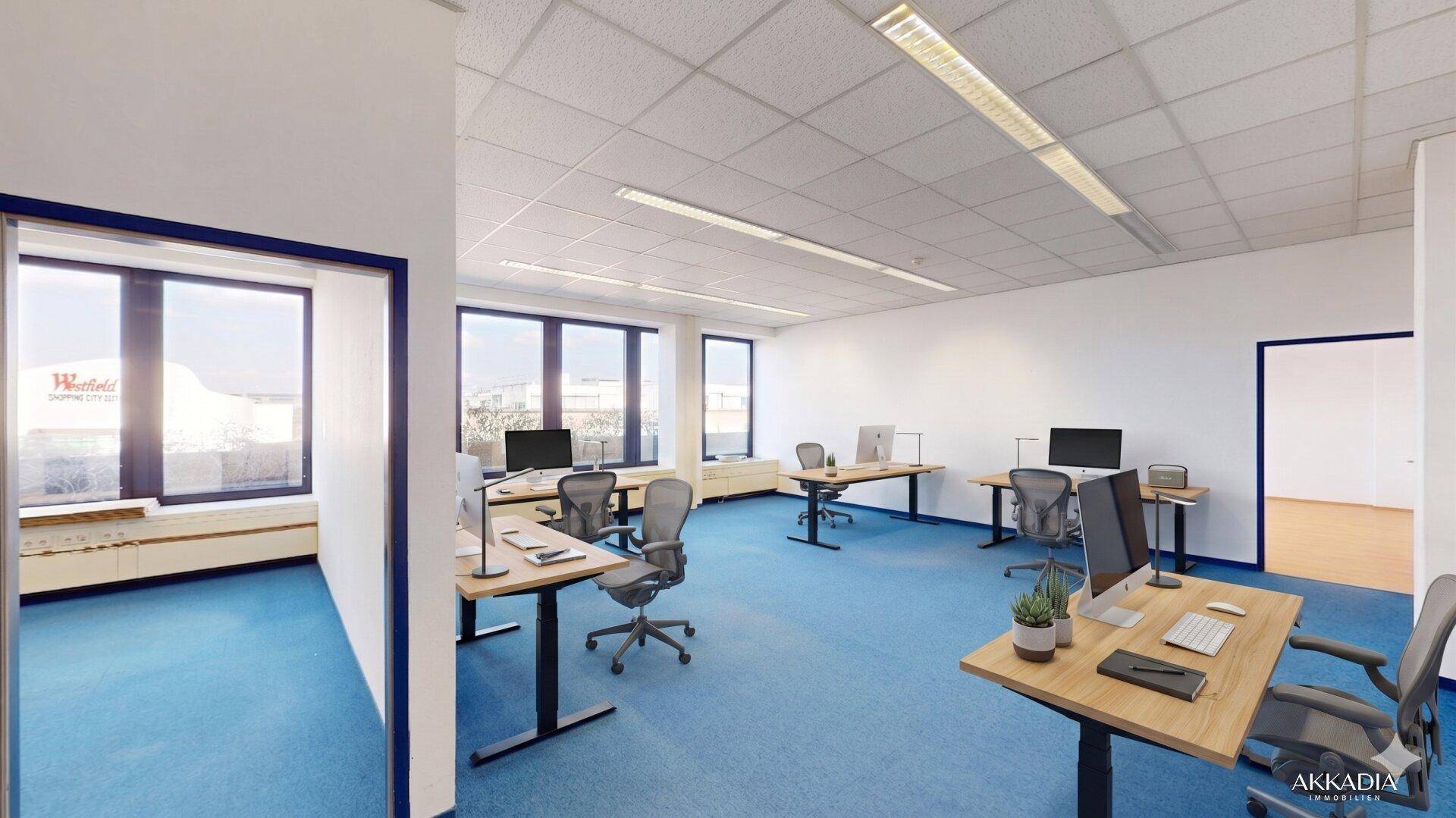 Großes, möbliertes Büro mit mehreren Arbeitsplätzen, blauer Teppichboden und viel Tageslicht.