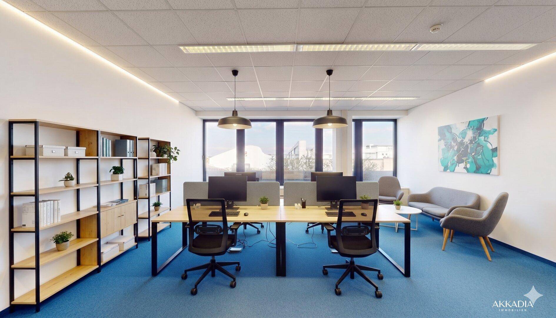 Modern eingerichtetes Büro mit mehreren Arbeitsplätzen, Regalen und einer gemütlichen Sitzecke.