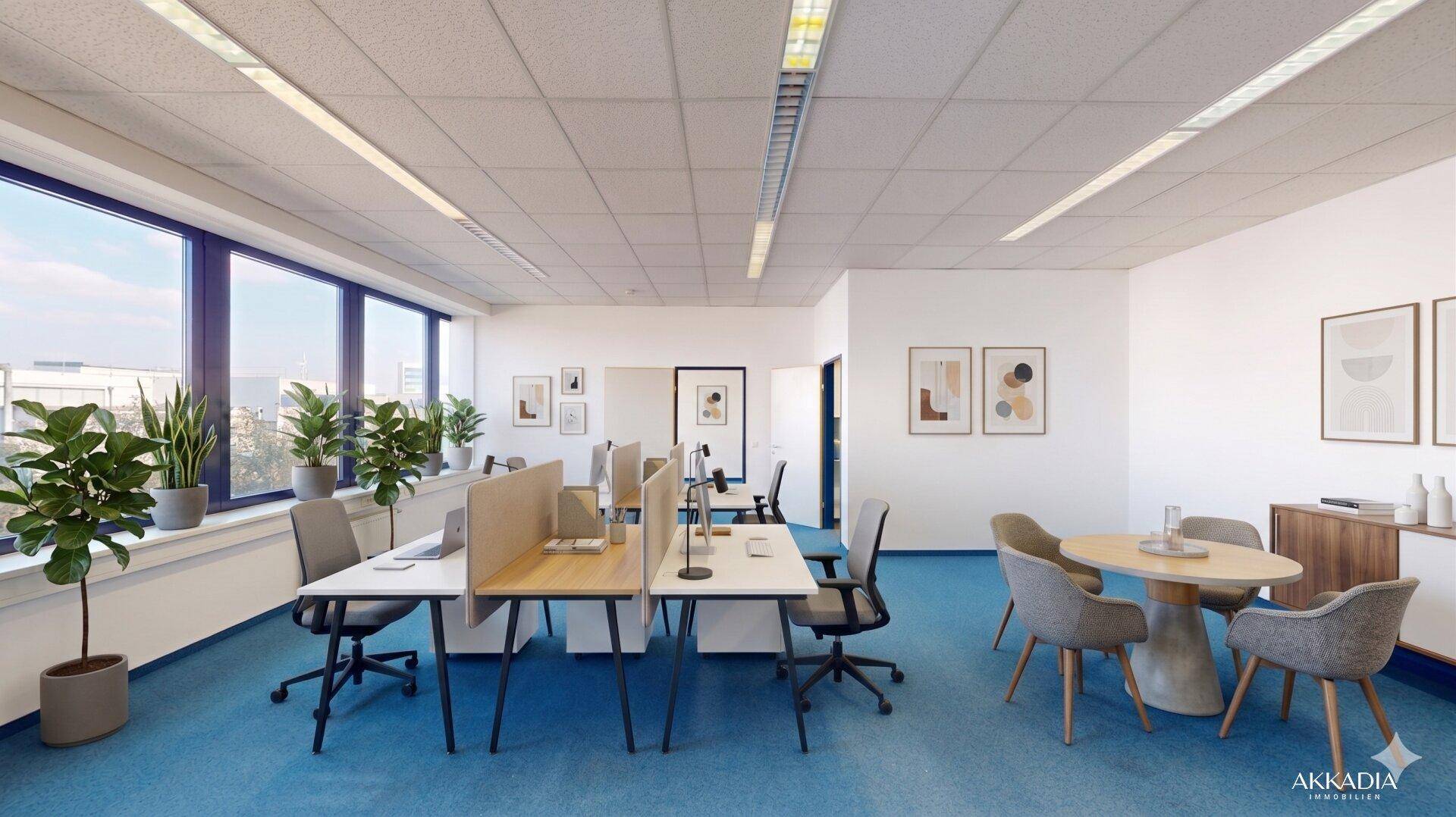 Offenes Büro mit mehreren Arbeitsplätzen, blauer Teppichboden und Pflanzen für eine angenehme Atmosphäre.