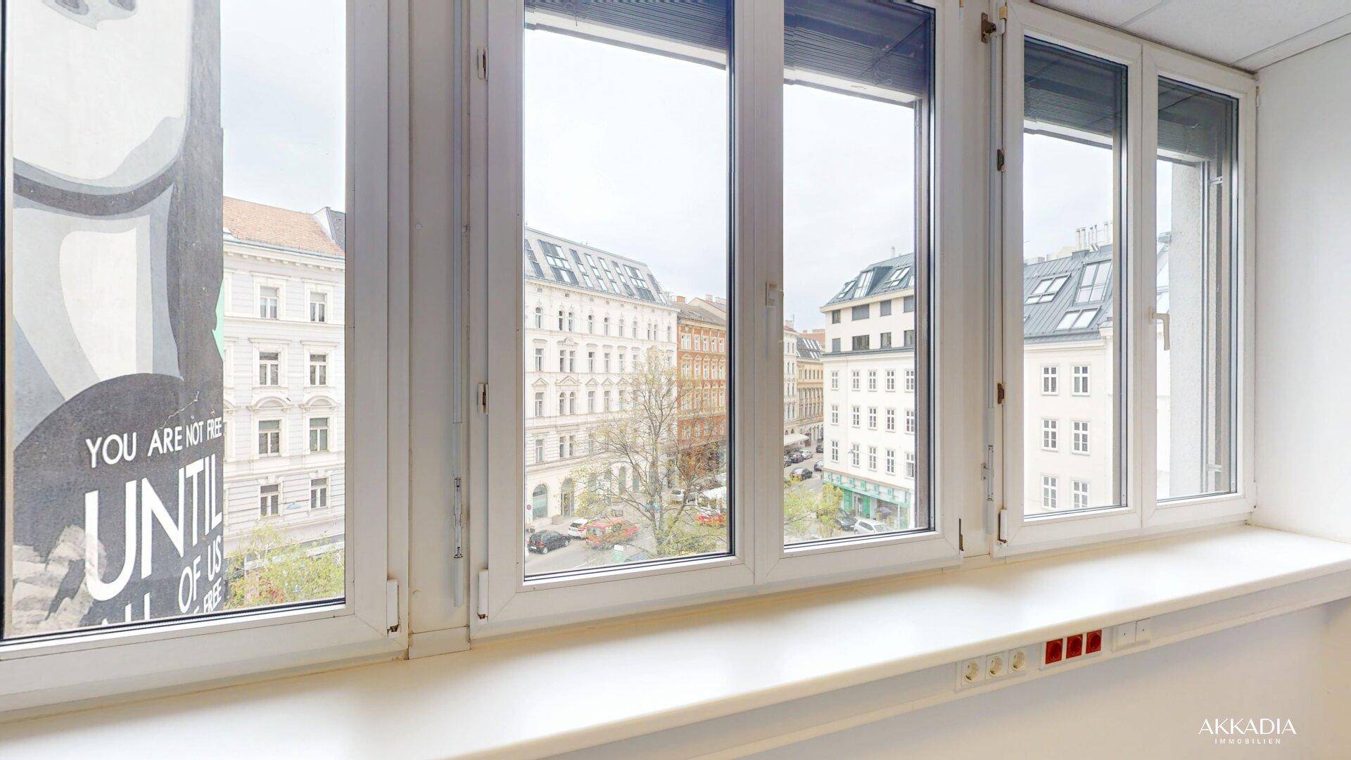 Blick aus dem Fenster eines Büros auf die umliegenden Gebäude und die Stadtlandschaft.