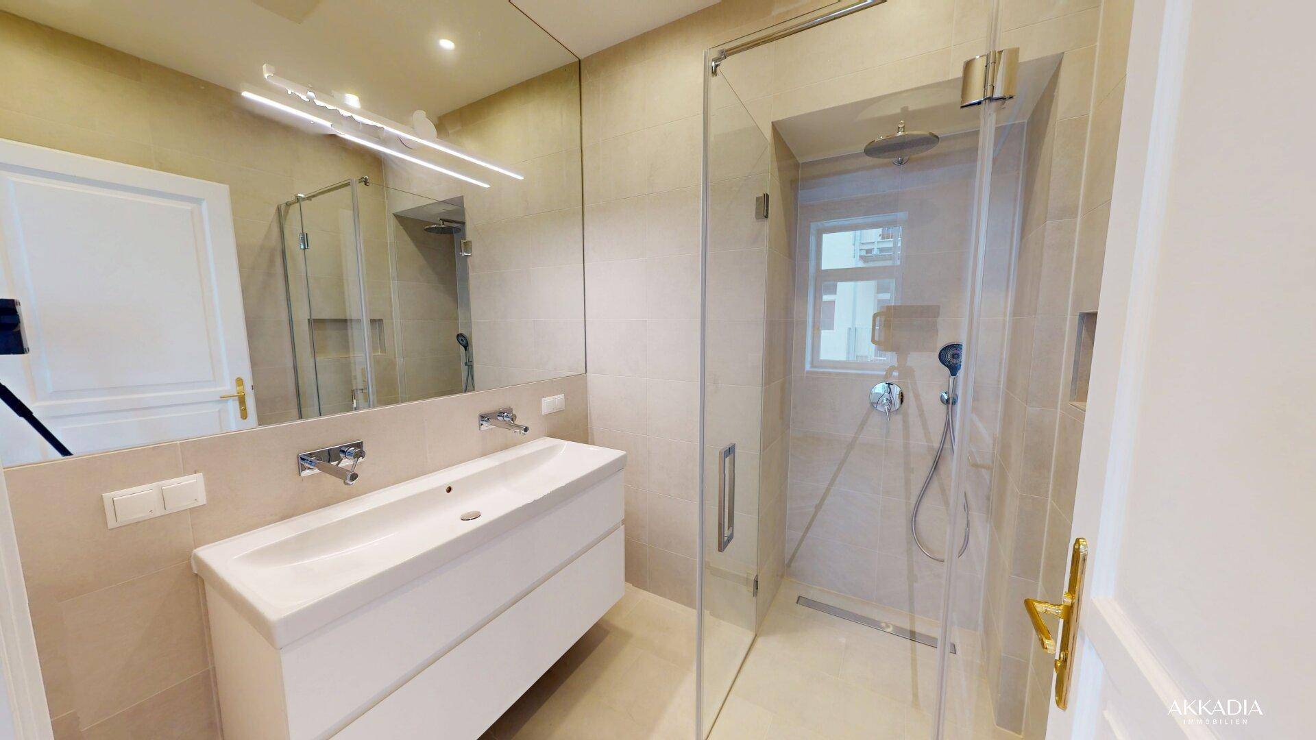 Modernes Badezimmer mit großem Spiegel, Einzelwaschbecken und einer geräumigen Duschkabine.