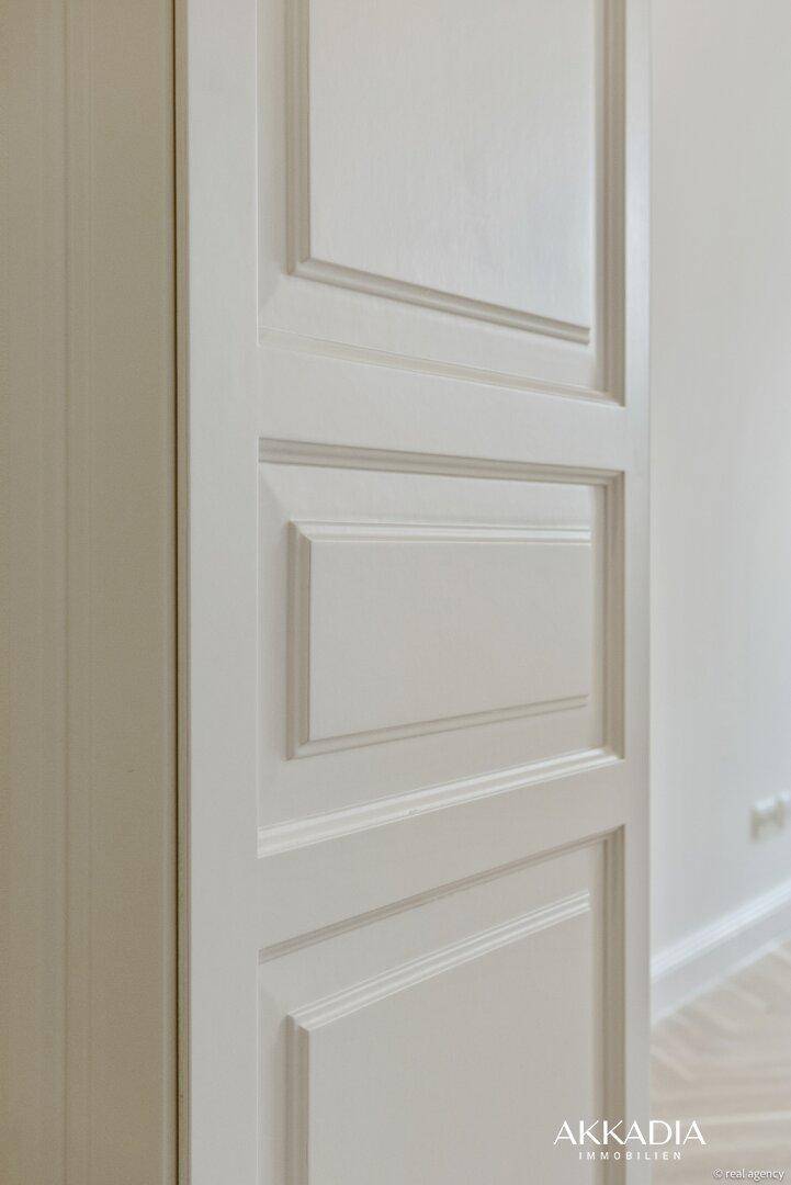 Elegante weiße Kassettentür mit klassischem Design, die den Stil des Innenraums ergänzt.