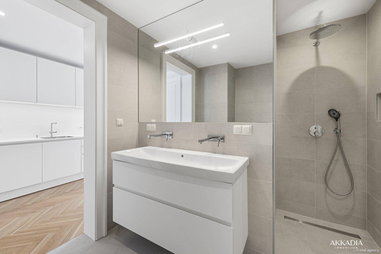 Modernes Badezimmer mit Waschtisch, Spiegelschrank und begehbarer Dusche.