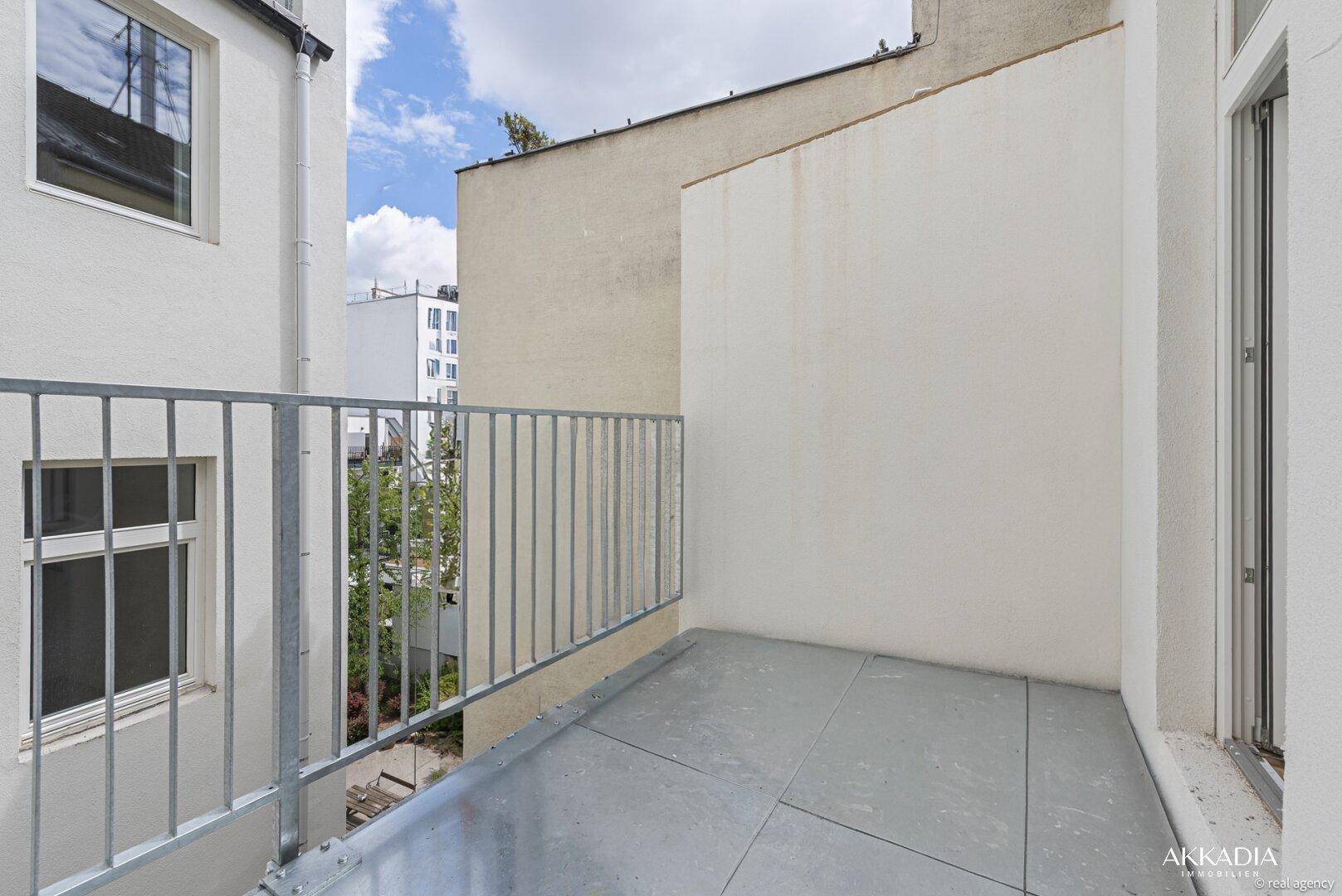Kleiner Balkon mit Metallgeländer und Blick auf die umliegenden Gebäude.