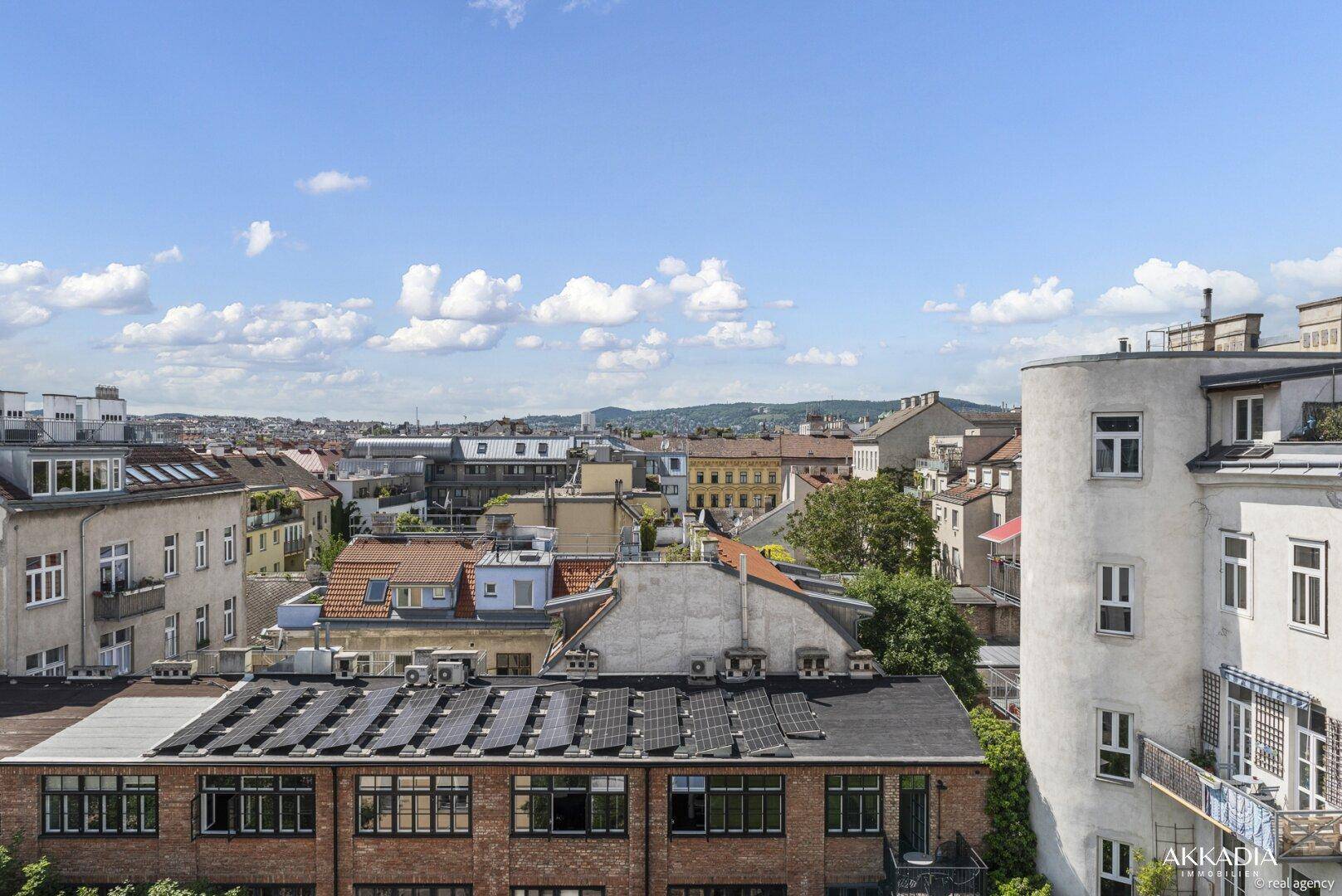 Panoramablick über die städtische Dachlandschaft mit vielfältiger Architektur und Solarmodulen.