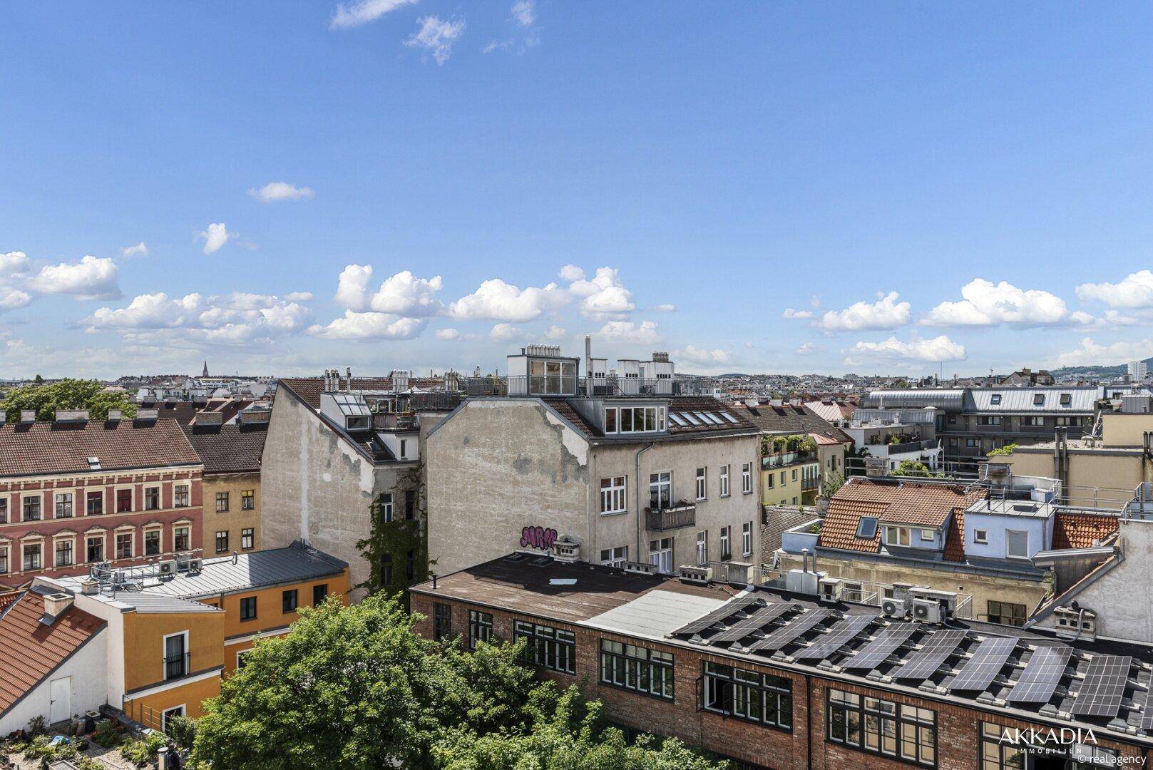 Weitläufiger Blick über die Dächer einer Stadt mit historischen Gebäuden und Solaranlagen.