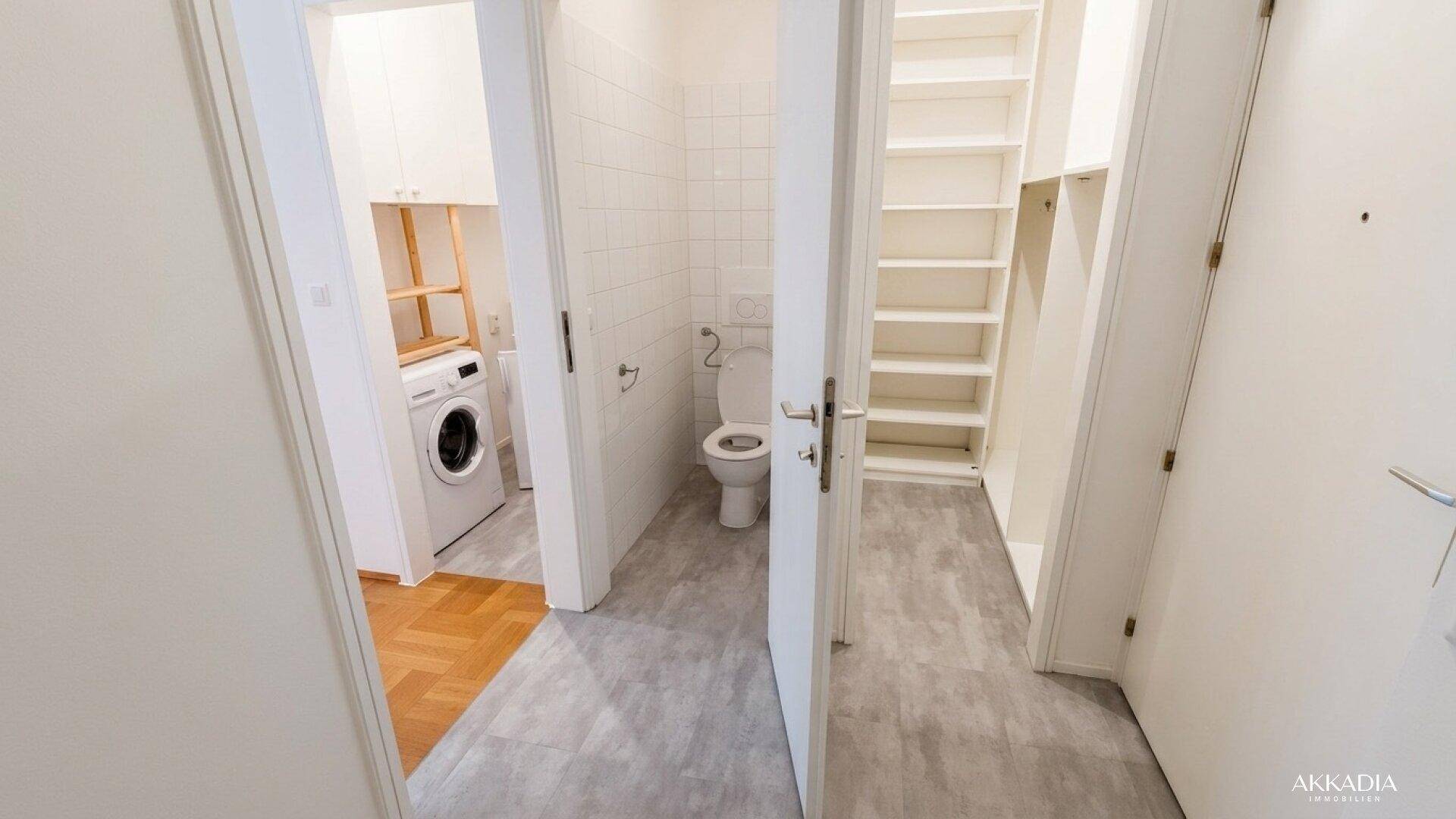 Praktischer Hauswirtschaftsraum mit Waschmaschine, Regalen und separatem WC.
