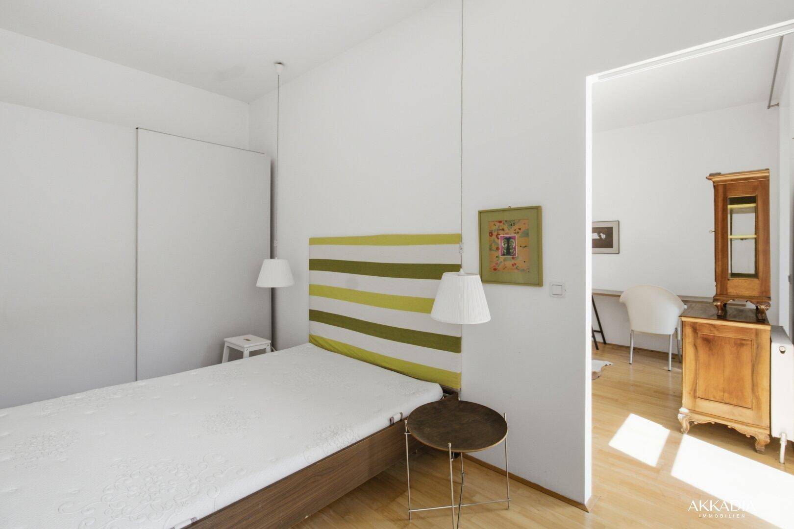 Schlafzimmer mit integriertem Kleiderschrank und Verbindung zum angrenzenden Wohnbereich.