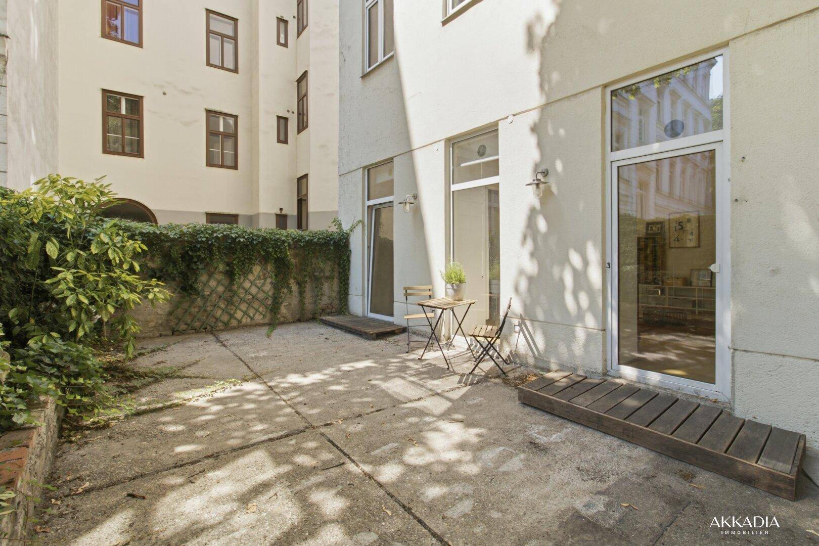 Geräumiger Terrassenbereich im Innenhof mit Sitzgelegenheiten und begrünten Wänden.