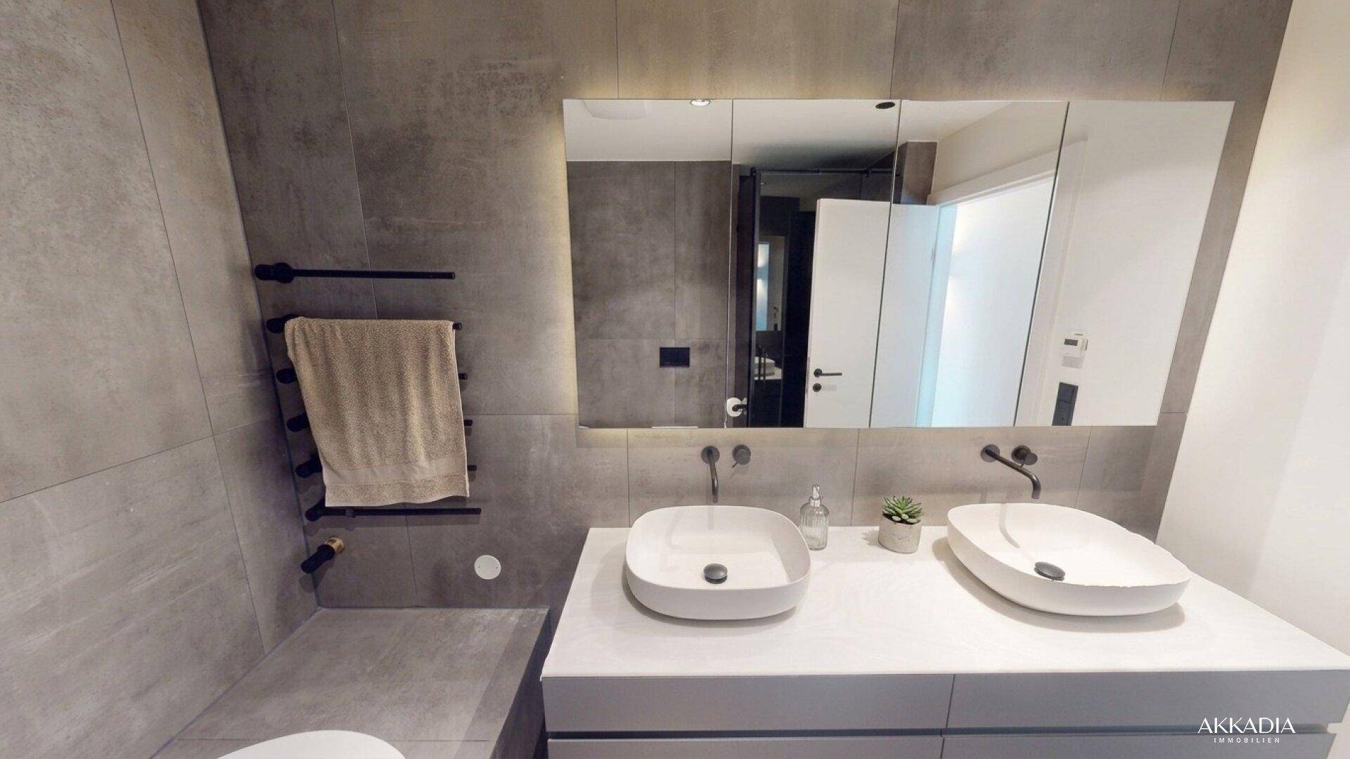 Modernes Badezimmer mit Doppelwaschbecken, großem Spiegelschrank und beheiztem Handtuchhalter.