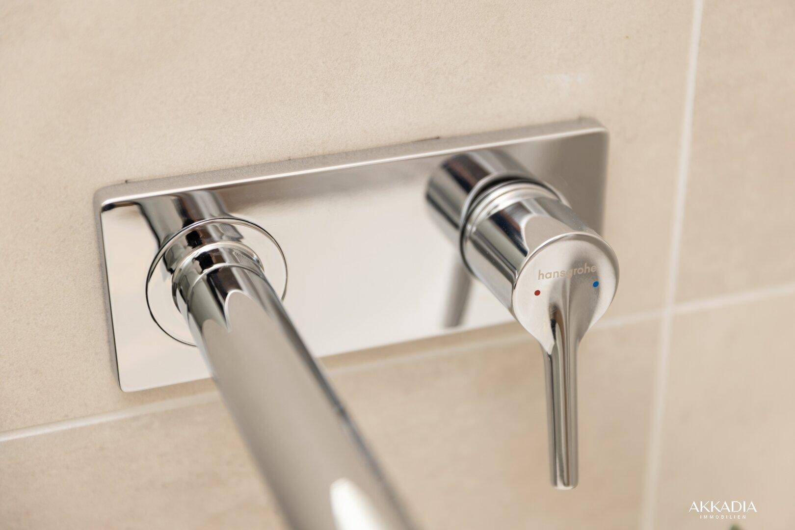 Detailansicht einer modernen Hansgrohe Duscharmatur an der gefliesten Wand.