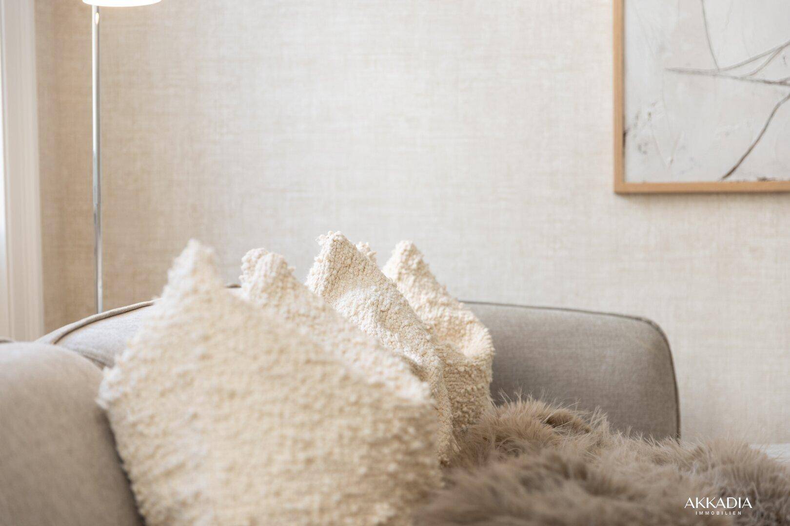Detailansicht von strukturierten Kissen und einer flauschigen Decke auf einem bequemen Sofa.
