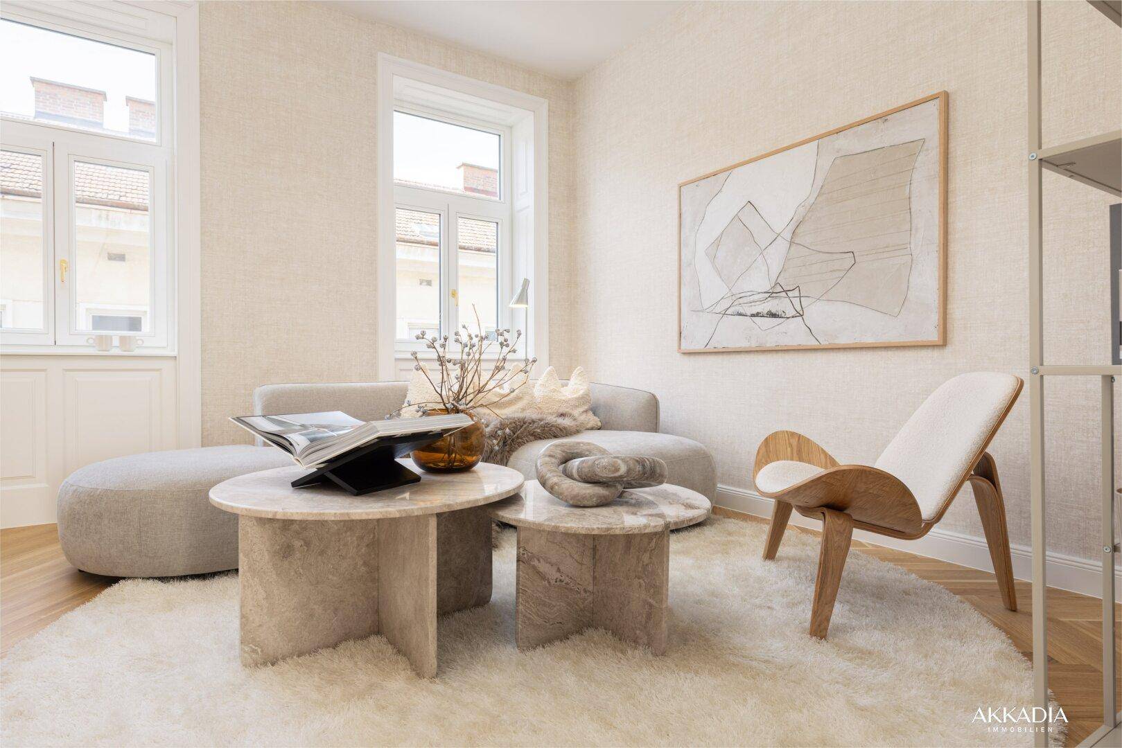 Lichtdurchfluteter Wohnbereich mit beigem Sofa, runden Couchtischen und großen Fenstern.
