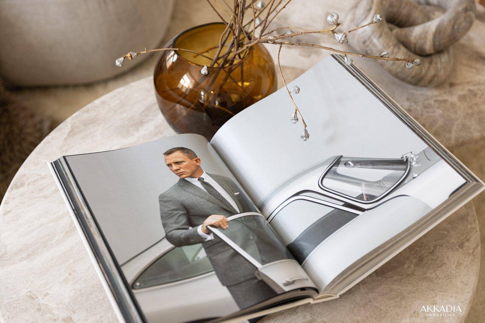 Nahaufnahme eines Buches mit Daniel Craig auf einem eleganten Couchtisch aus Stein.