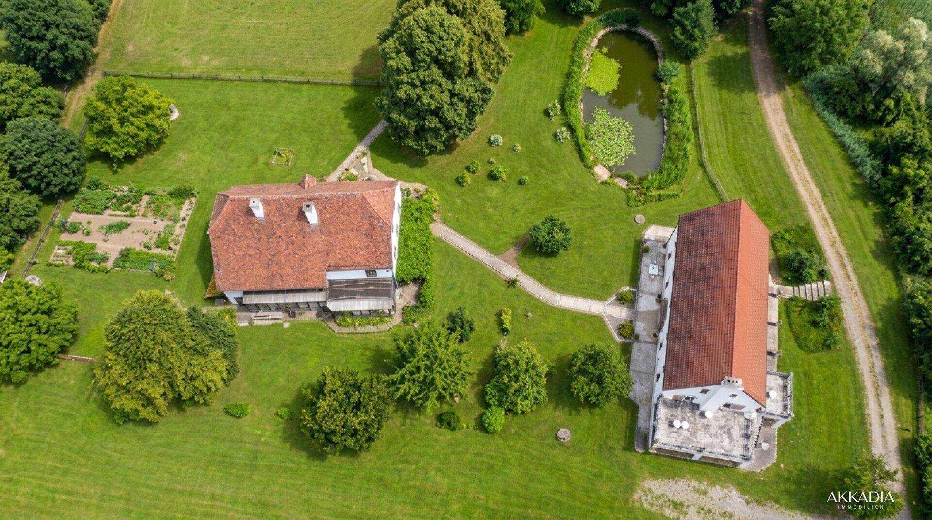 Luftaufnahme des Anwesens mit großem Garten, Teich und angrenzendem Küchengarten.