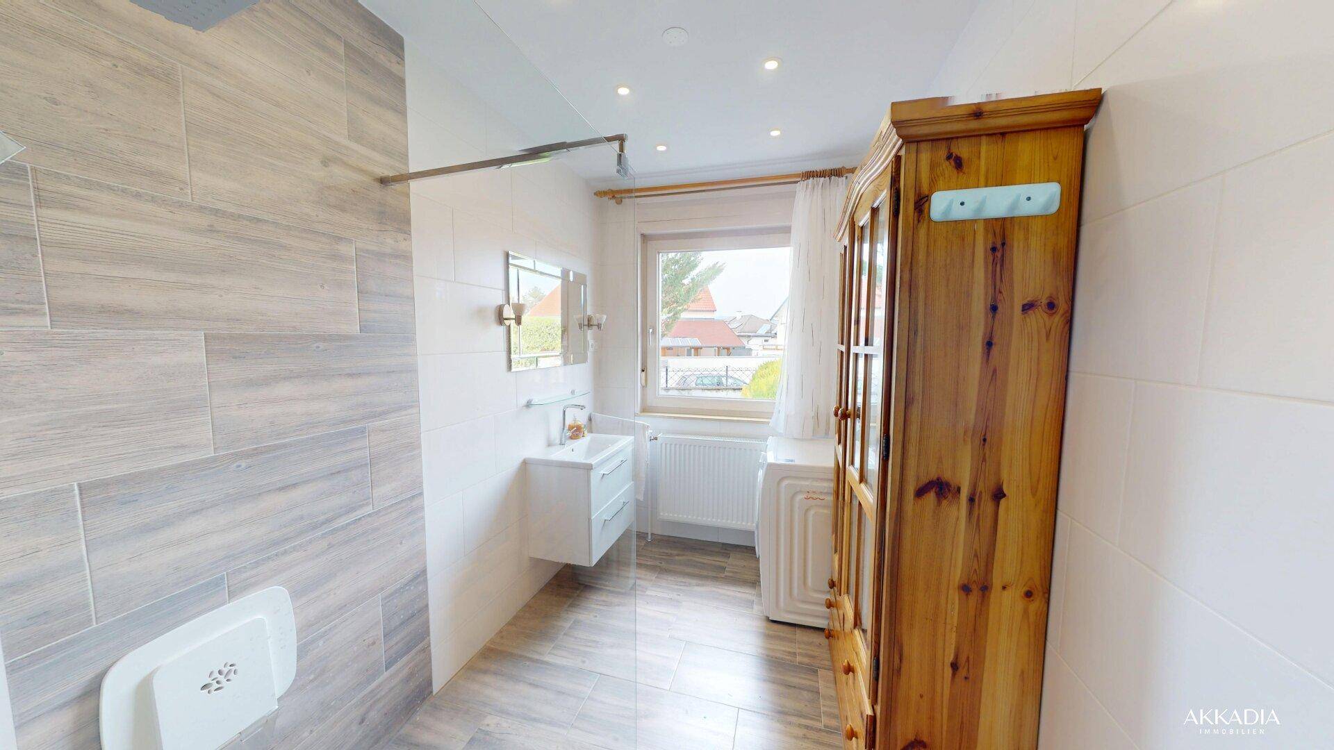Modernes Badezimmer mit ebenerdiger Dusche, Einzelwaschbecken und einem Fenster für Tageslicht.