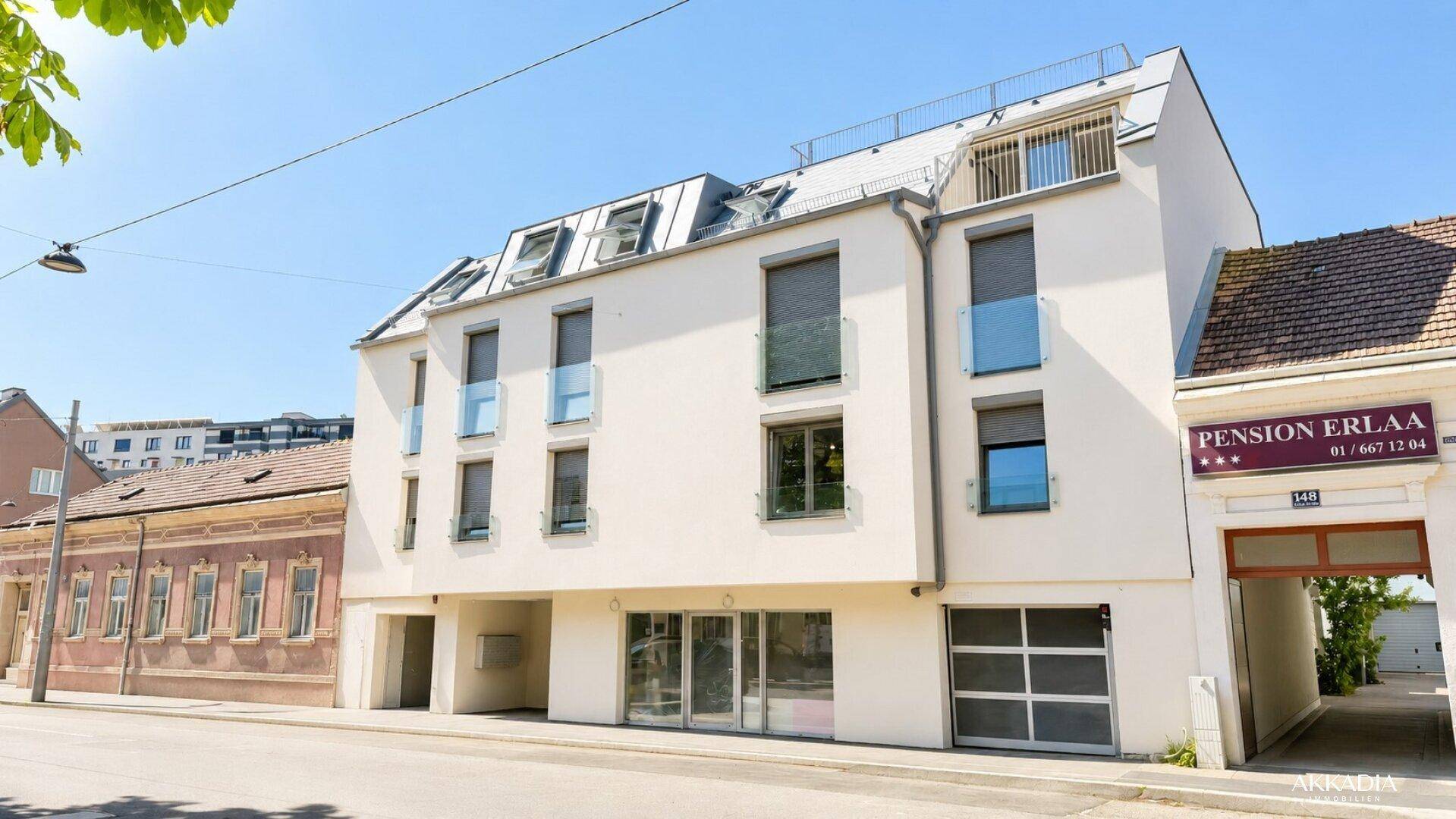 Ansicht der modernen Wohnanlage von der Straße mit angrenzender Pension.