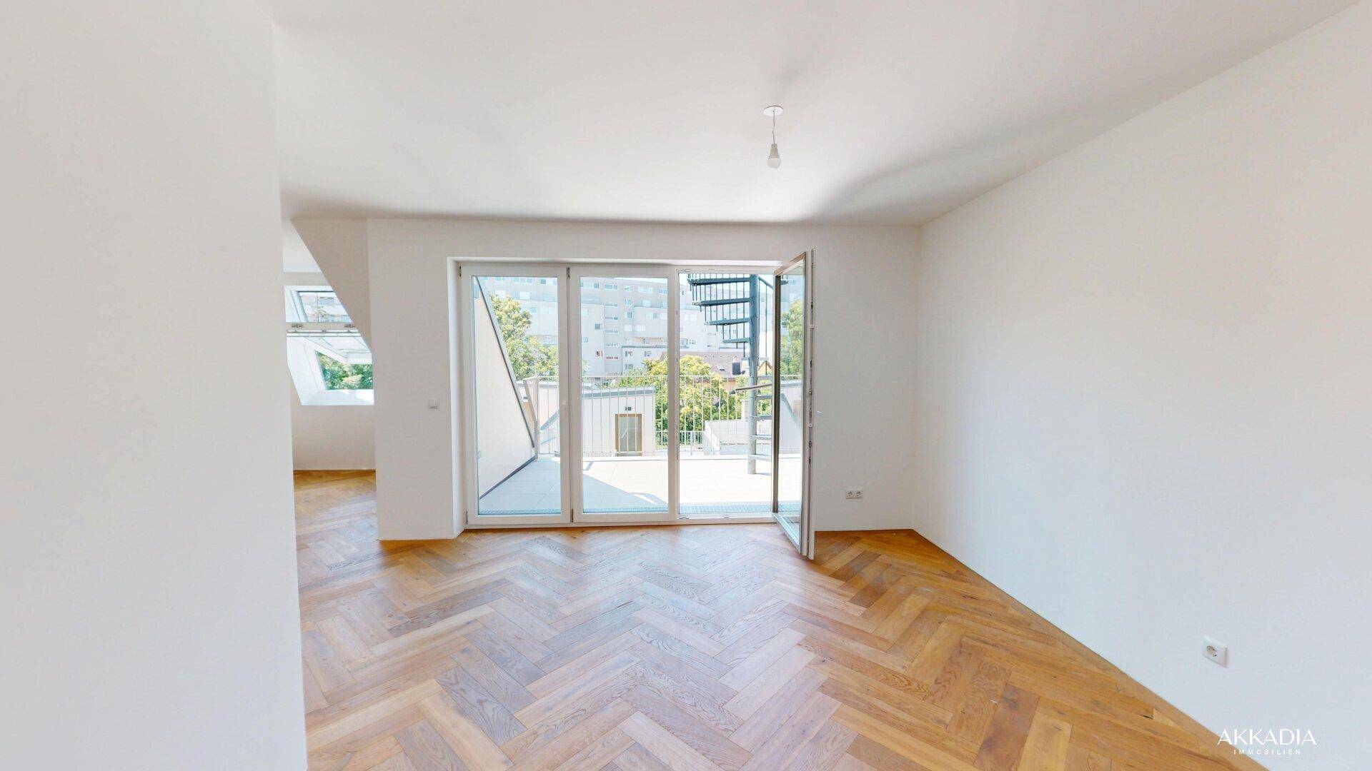 Geräumiger, heller Raum mit Fischgrätparkett und direktem Zugang zur Dachterrasse.