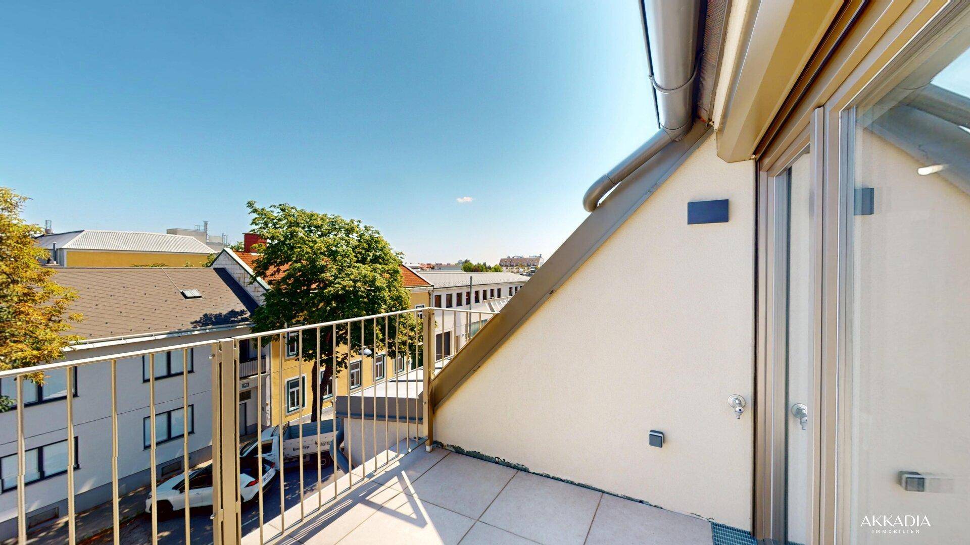 Kleiner Balkon mit Metallgeländer und Blick auf die umliegende Stadtbebauung.