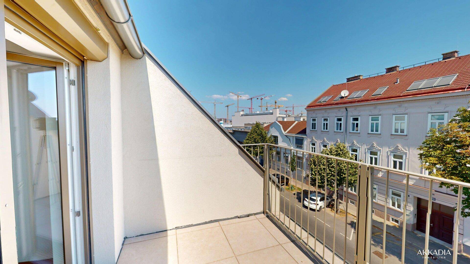 Kleiner Balkon mit Metallgeländer und Blick auf die umliegende Stadtbebauung.