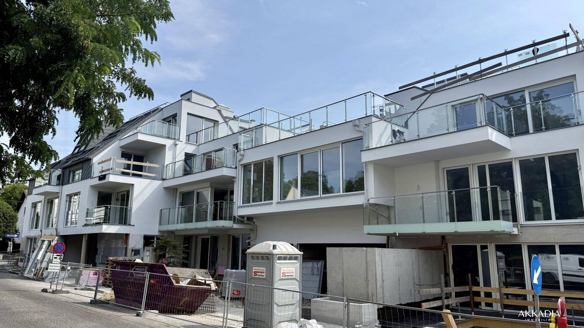 Neubau eines modernen Wohngebäudes mit mehreren Balkonen und Dachterrassen.