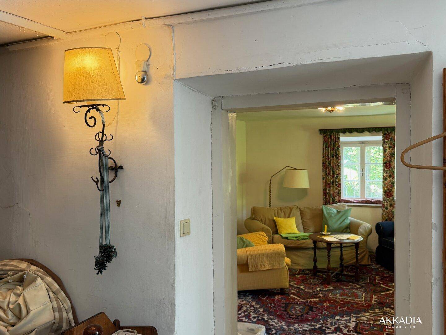 Traditionelles Wohnzimmer mit gemütlichem Sofa, Teppich und Fensterblick.