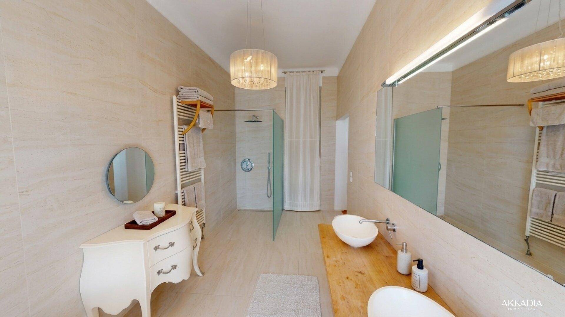 Modernes Badezimmer mit begehbarer Dusche, Doppelwaschbecken und beigefarbenen Fliesen.