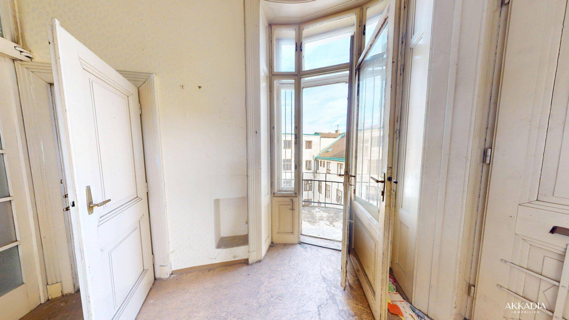 Kleiner Raum mit Zugang zu einem französischen Balkon und Blick auf die Umgebung.