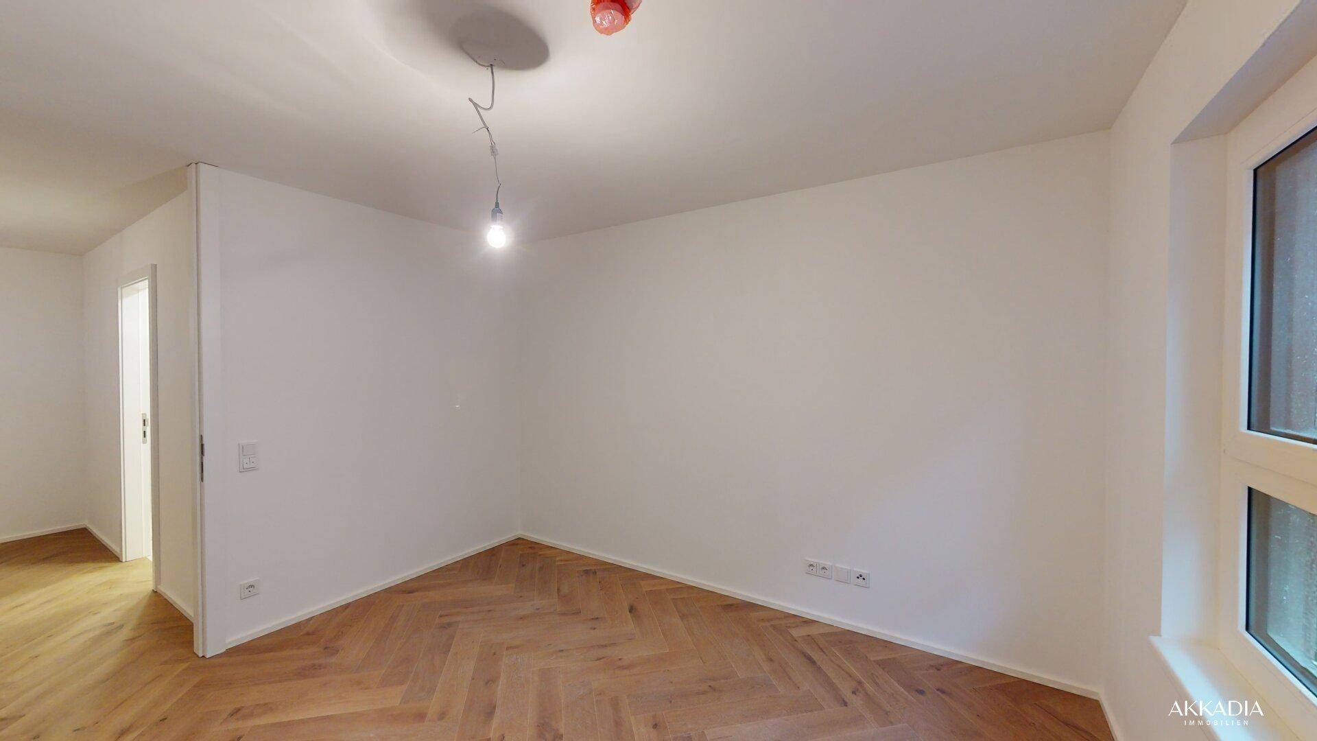 Helles Zimmer mit Fischgrätparkett und weiß gestrichenen Wänden, bereit zur Einrichtung.