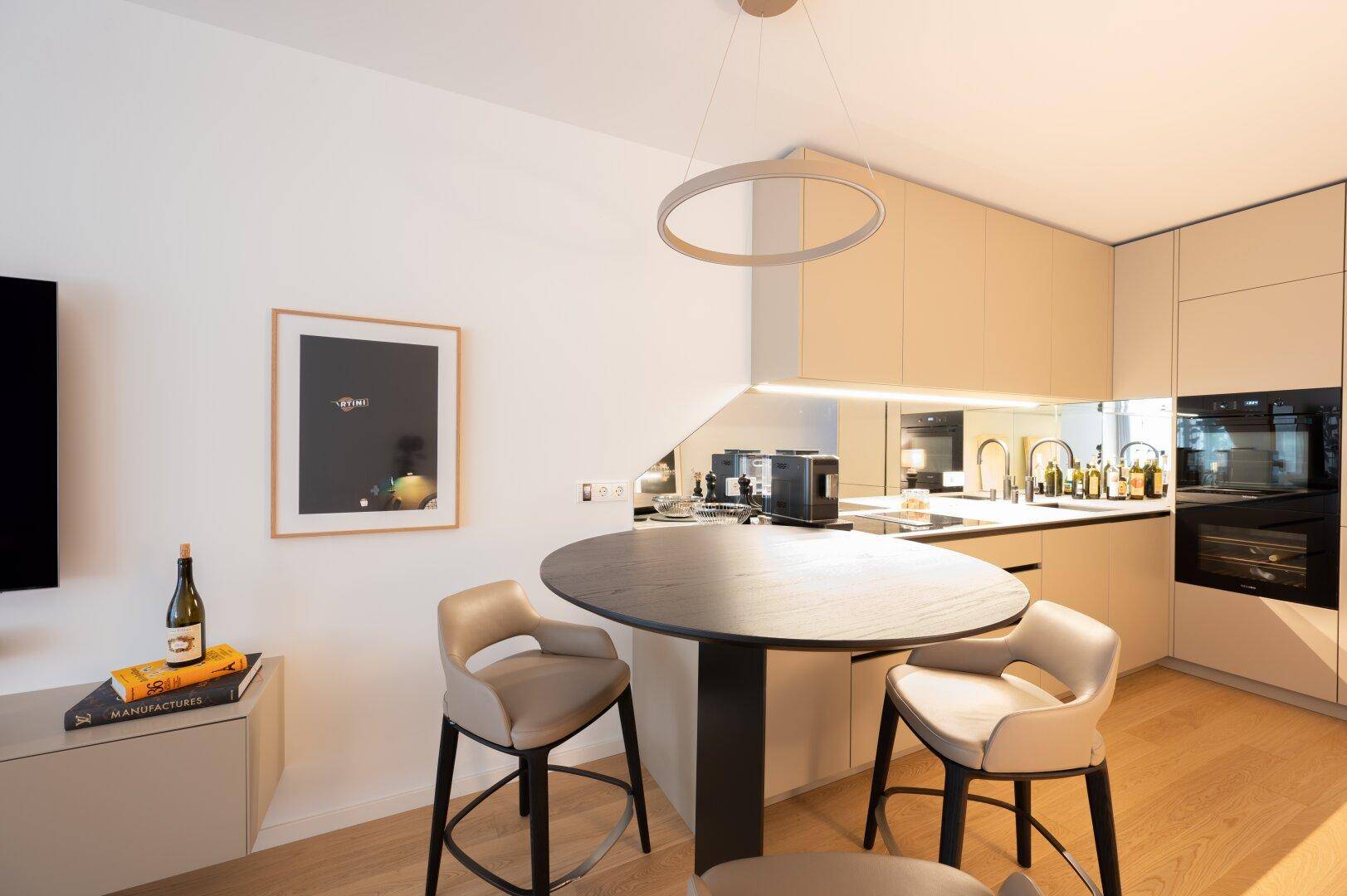 Moderne Küche mit integrierten Geräten, einer Kücheninsel und stilvollen Barhockern.