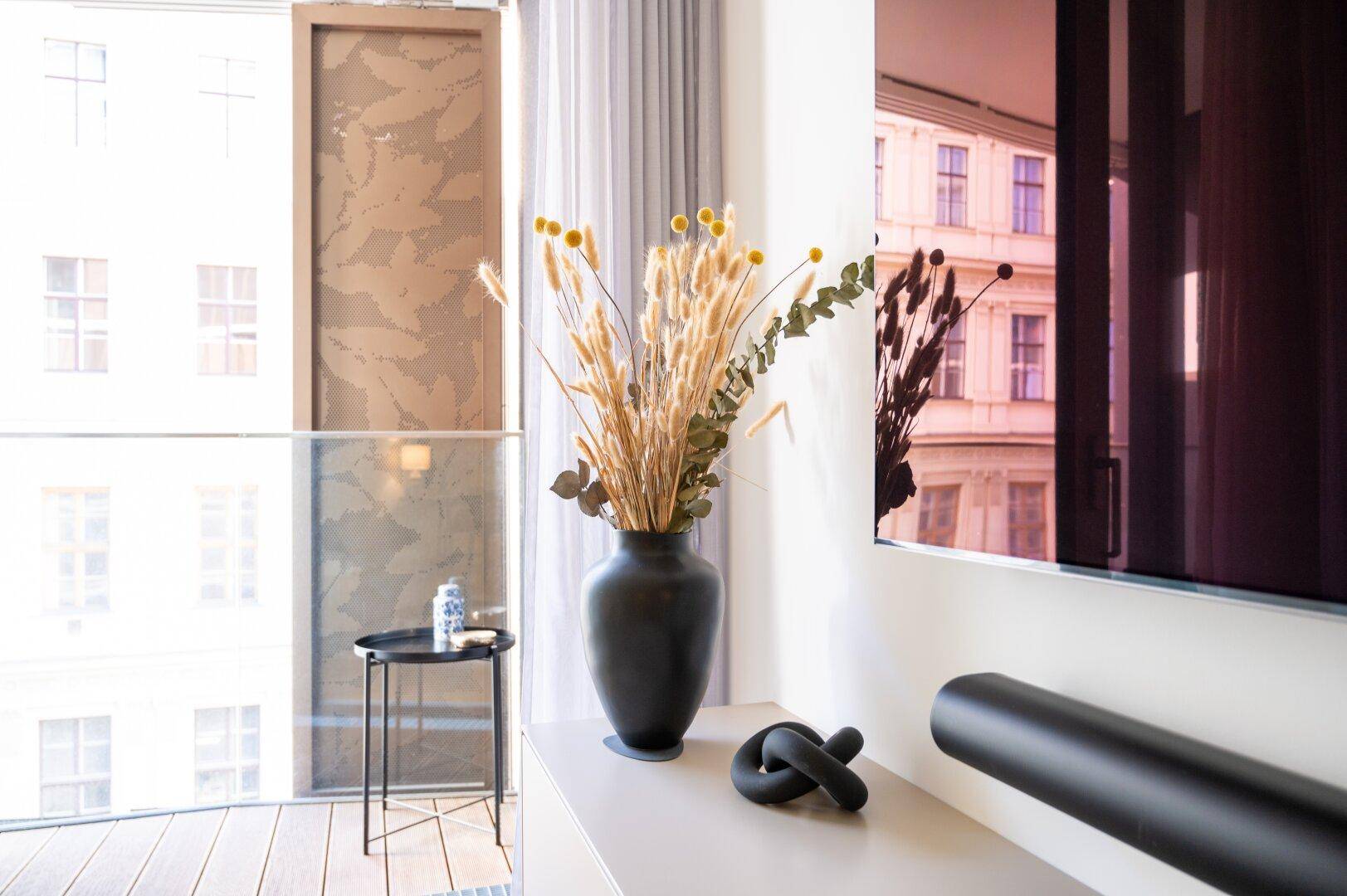 Detailansicht des Fensters im Wohnzimmer mit Blick auf die Stadt und dekorativen Elementen.