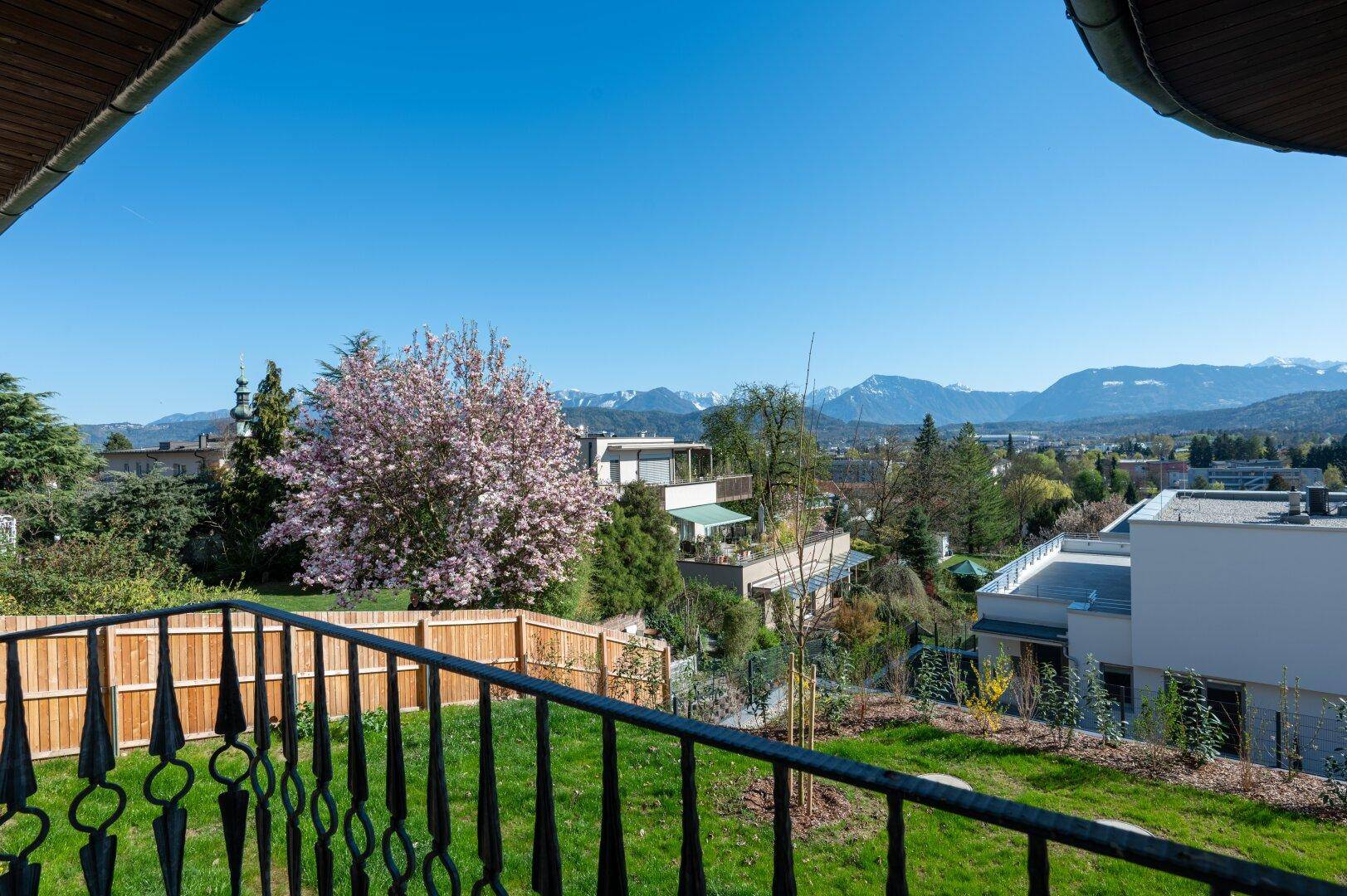 Panoramablick vom Garten auf die umliegende Landschaft und die majestätischen Berge.