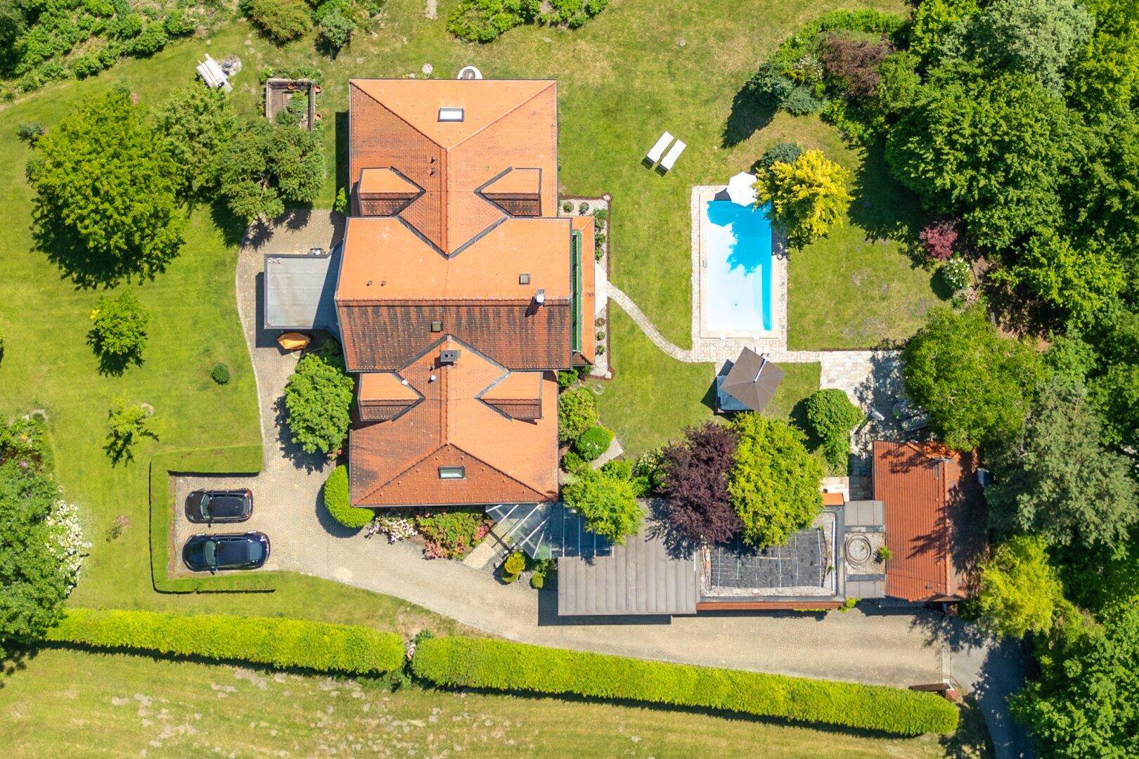 Luftaufnahme des Anwesens mit großem Garten, Pool und weitläufiger Grünfläche.