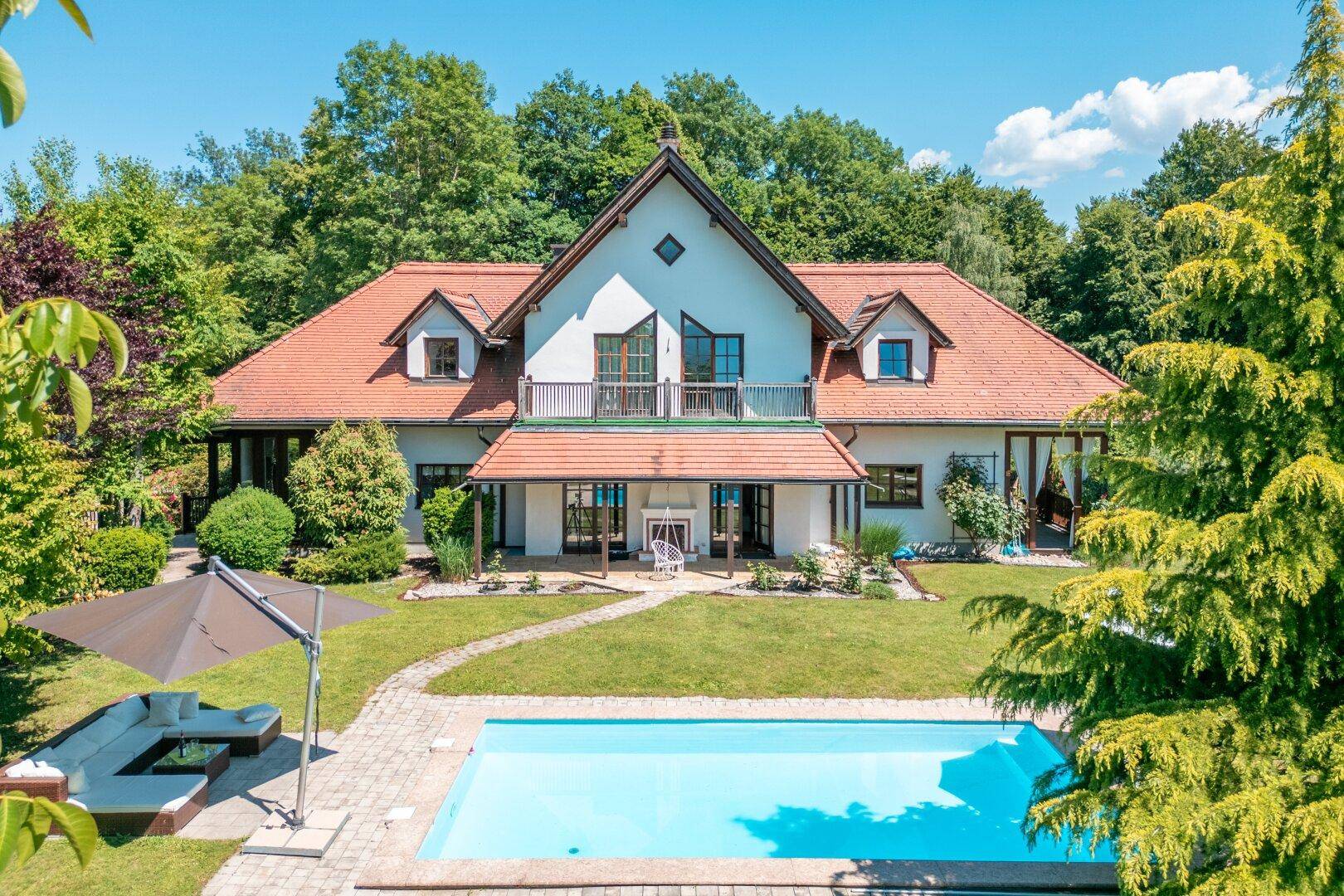 Weitläufiger Gartenbereich mit großem Pool, Liegewiese und dem Haupthaus.