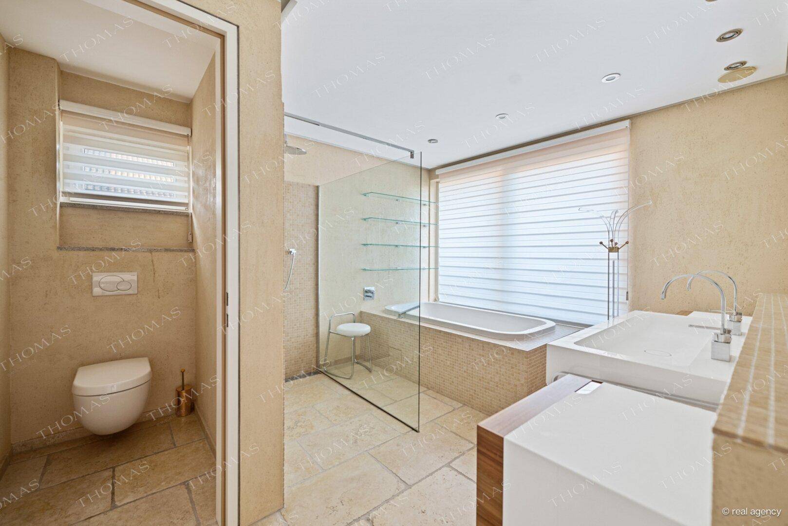 Modernes Badezimmer mit Badewanne, begehbarer Dusche und Doppelwaschbecken.