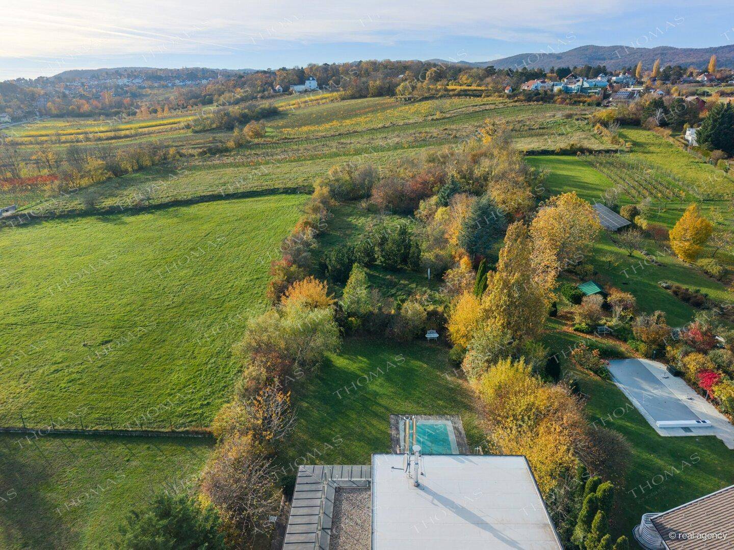 Luftaufnahme der Liegenschaft mit weitläufigem Grundstück und umliegender Naturlandschaft.