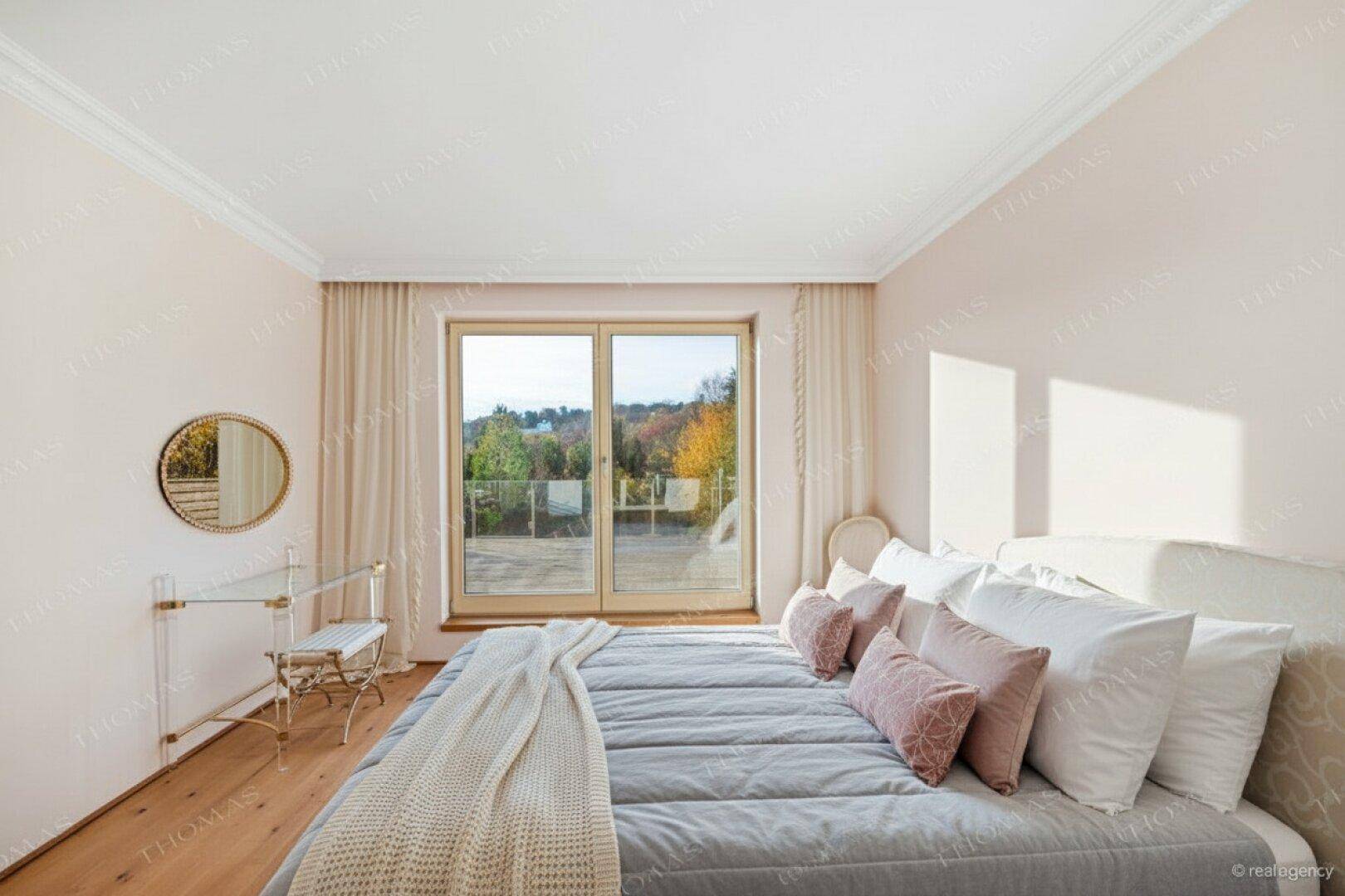 Gemütliches Schlafzimmer mit Holzboden, Balkonzugang und beruhigendem Blick ins Grüne.