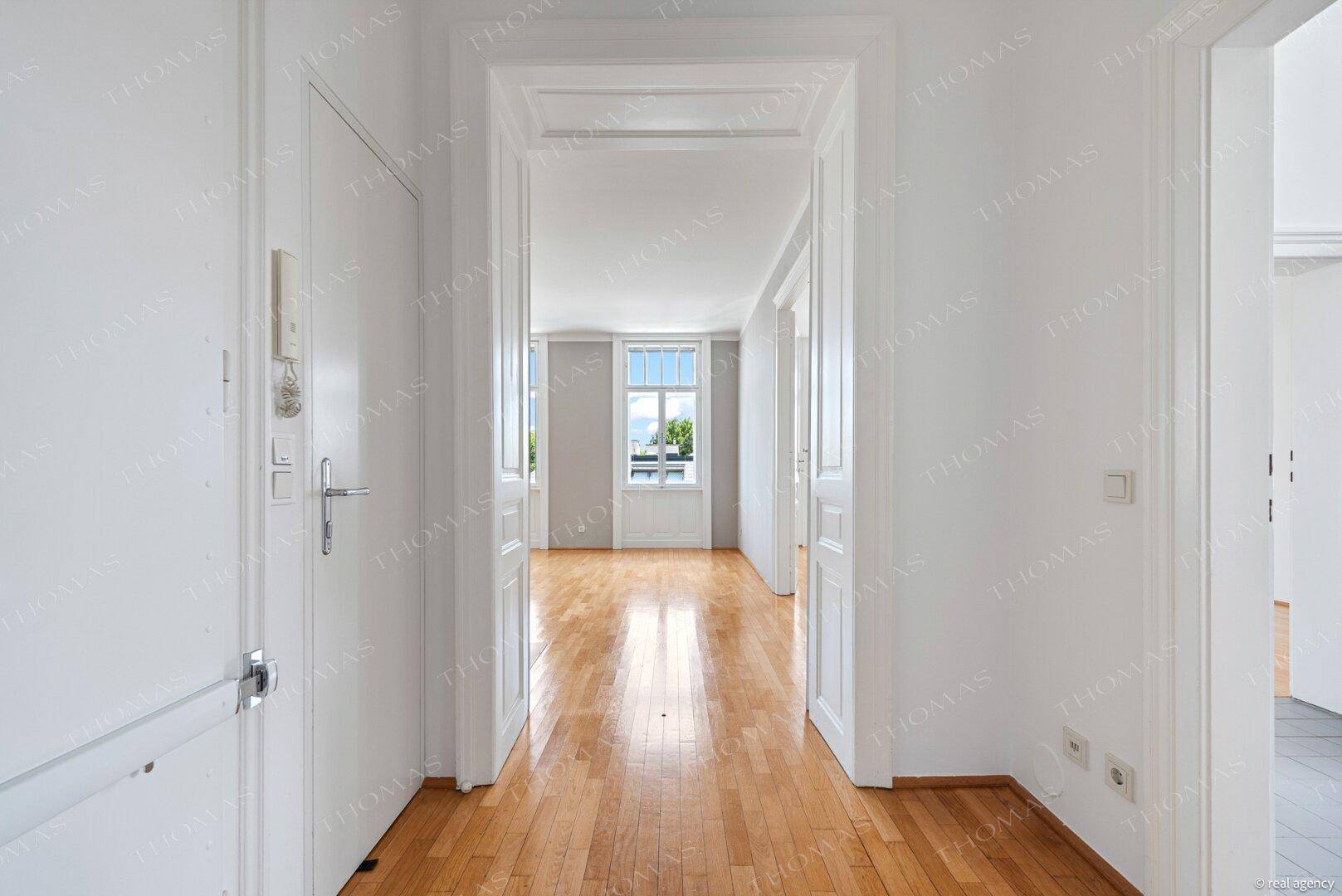 Geräumiger Flur mit Parkettboden, der zu den hellen Wohnbereichen der Wohnung führt.