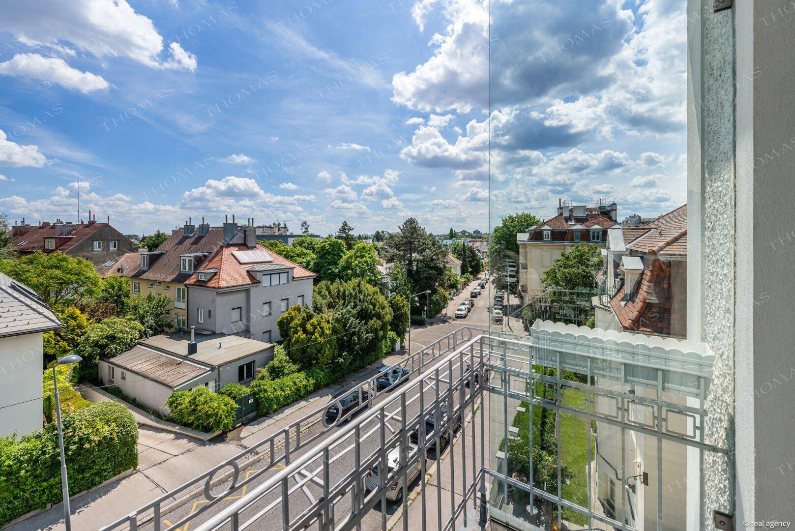 Sonniger Balkon mit weitem Blick über die Straße und die charmante Nachbarschaft.