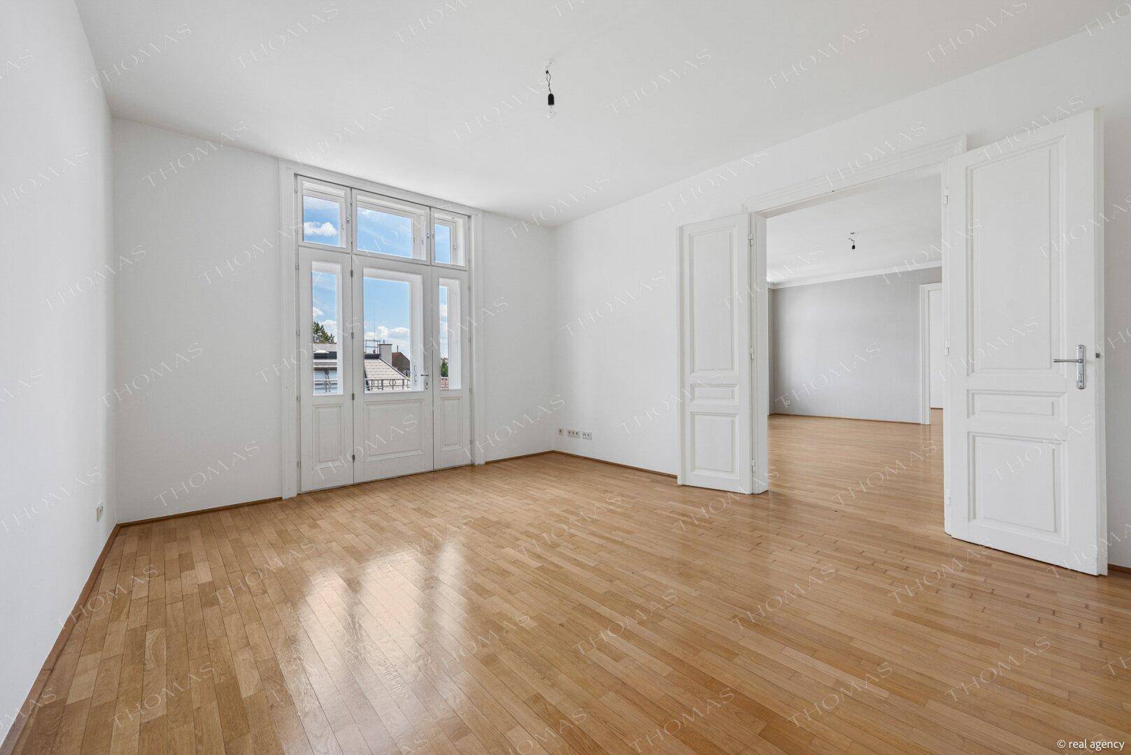 Geräumiger, heller Raum mit Parkettboden und hohen Fenstern, ideal für individuelle Gestaltung.