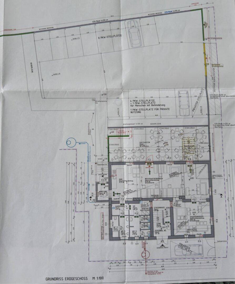 Gefalteter Grundriss des Erdgeschosses mit Parkplätzen und der Raumaufteilung eines Gebäudes.