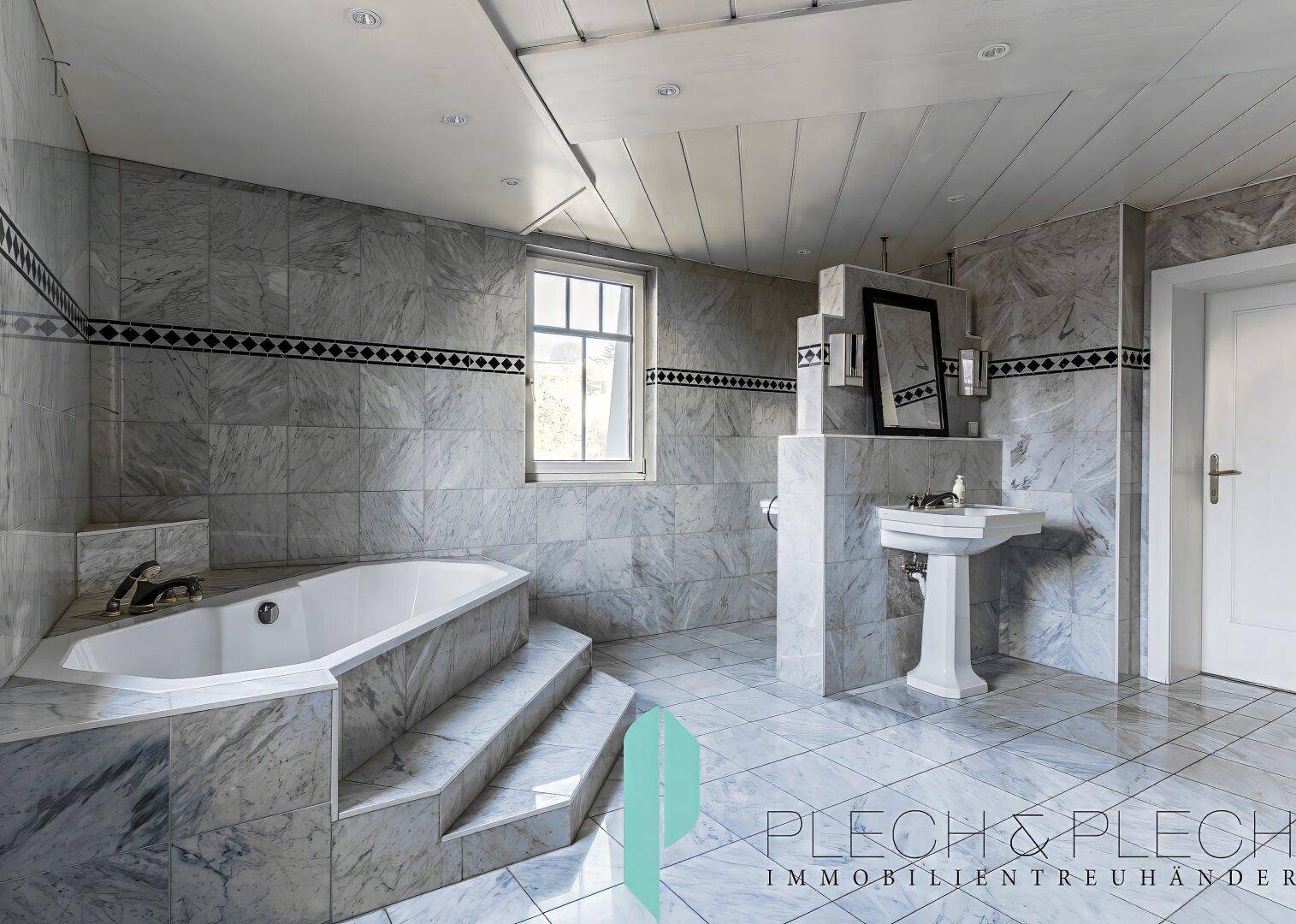 Elegantes Badezimmer mit Eckbadewanne, Marmorfliesen und separatem Waschtisch.